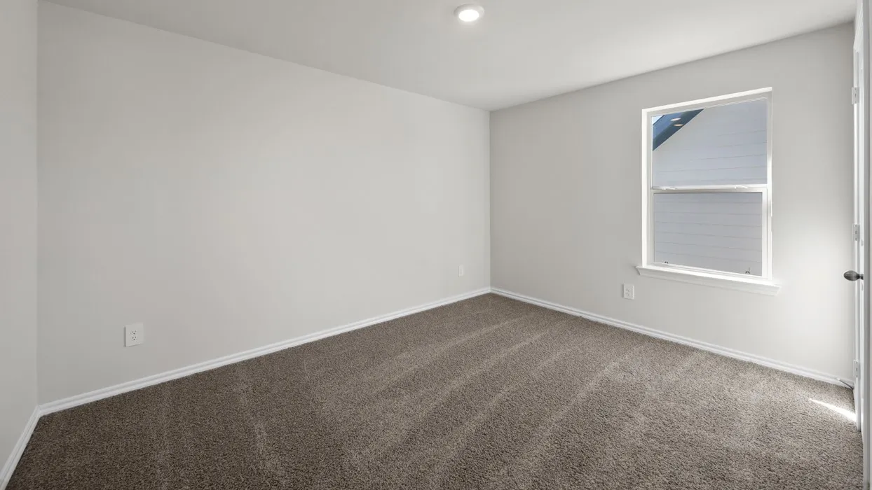 Neutral wall color, recessed ceiling lighting, light brown carpet, white trim, and a window with a white frame