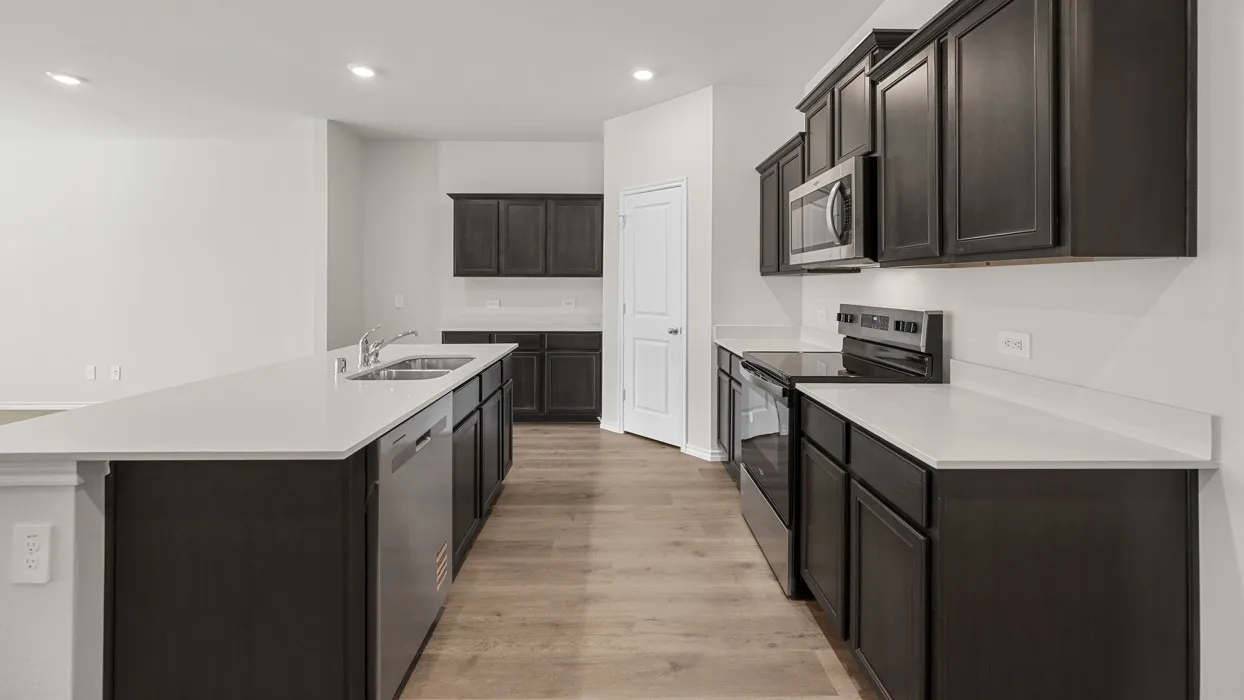 Kitchen featuring dark wood-finish cabinetry, light-toned countertops, stainless steel appliances, and wood-finish flooring