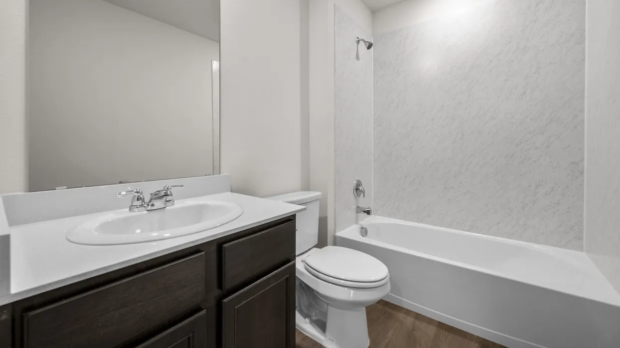 Vanity with an integrated sink, polished chrome faucet, dark wood-finish cabinetry, and a full-width mirror