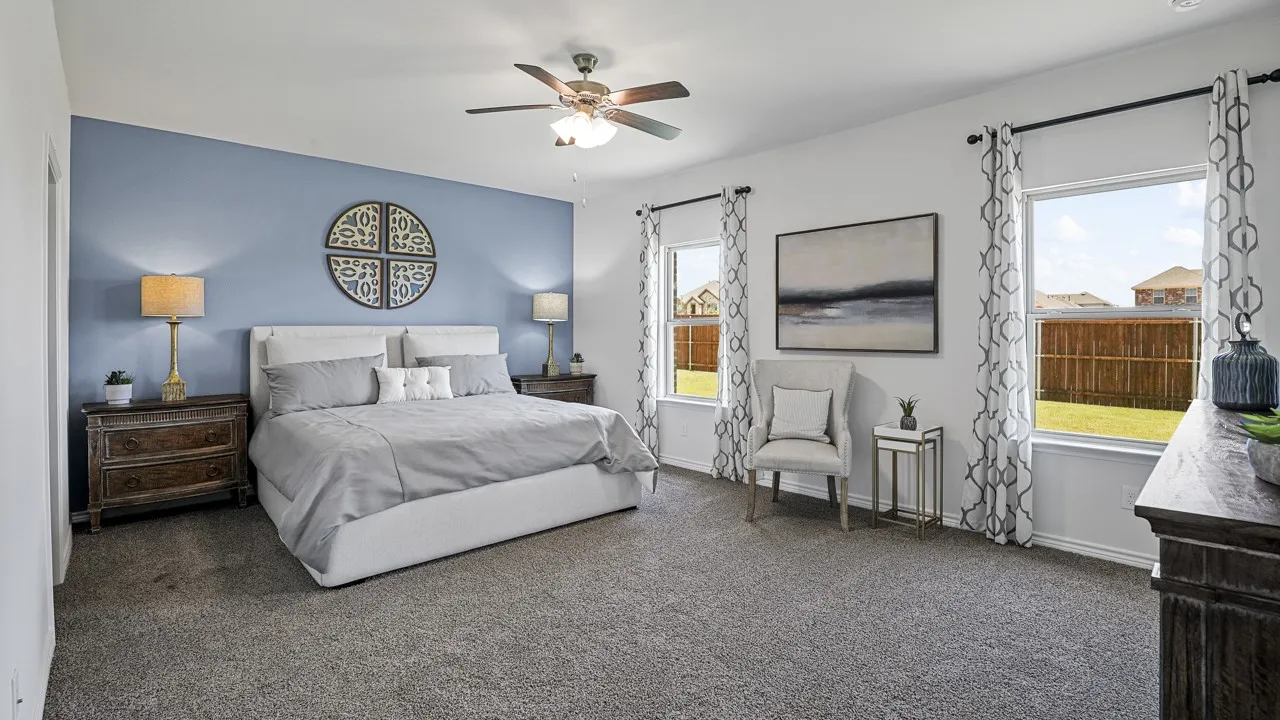 Spacious room featuring carpeted flooring, a ceiling fan, and multiple windows