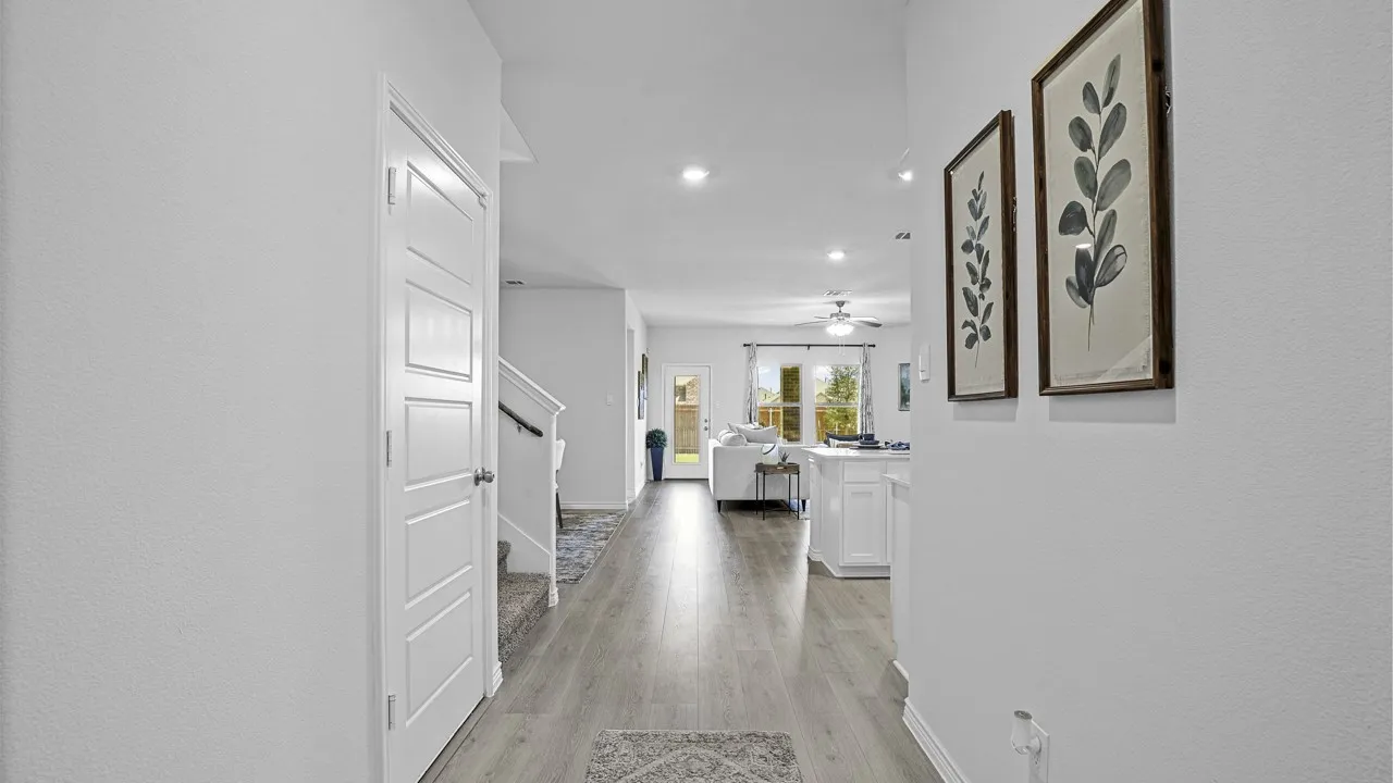Recessed lighting, wood-finish flooring, white paneled door, and staircase with railing