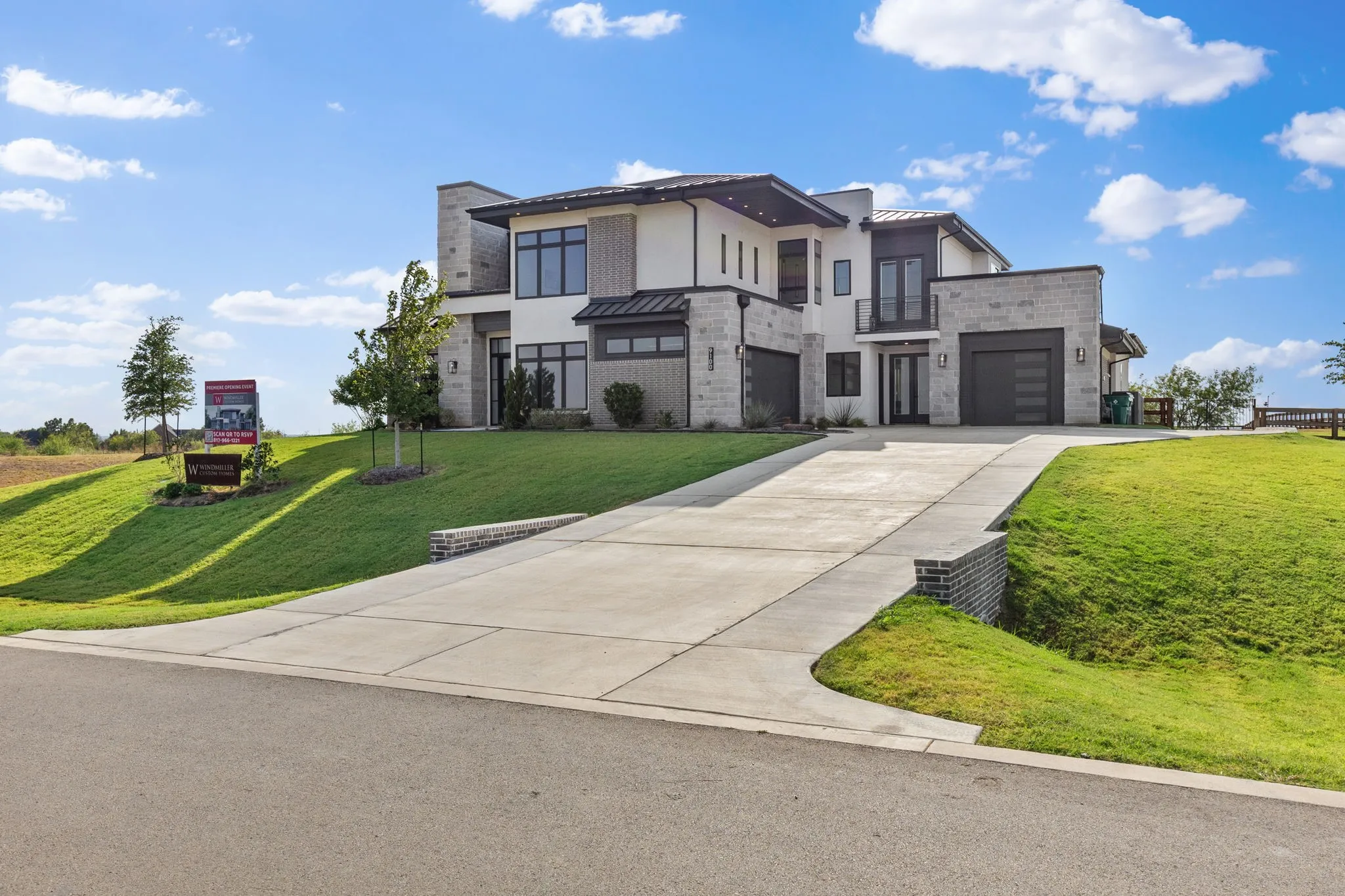 Modern exterior featuring multiple stone and stucco finishes, a concrete driveway, and an attached two-car garage