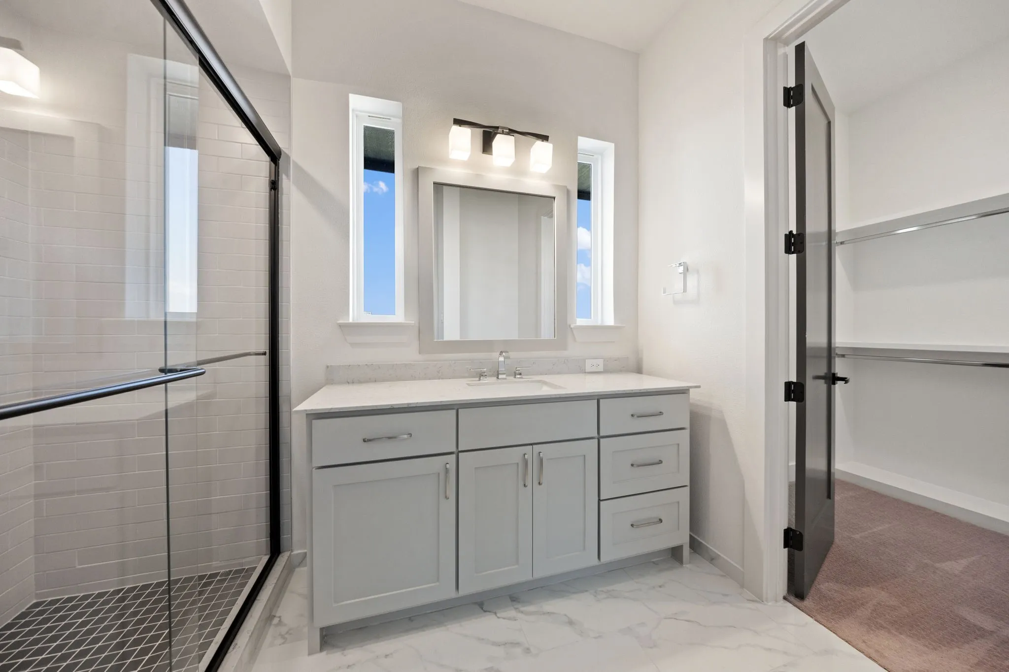 Vanity with light gray shaker cabinetry, quartz countertop, and integrated sink