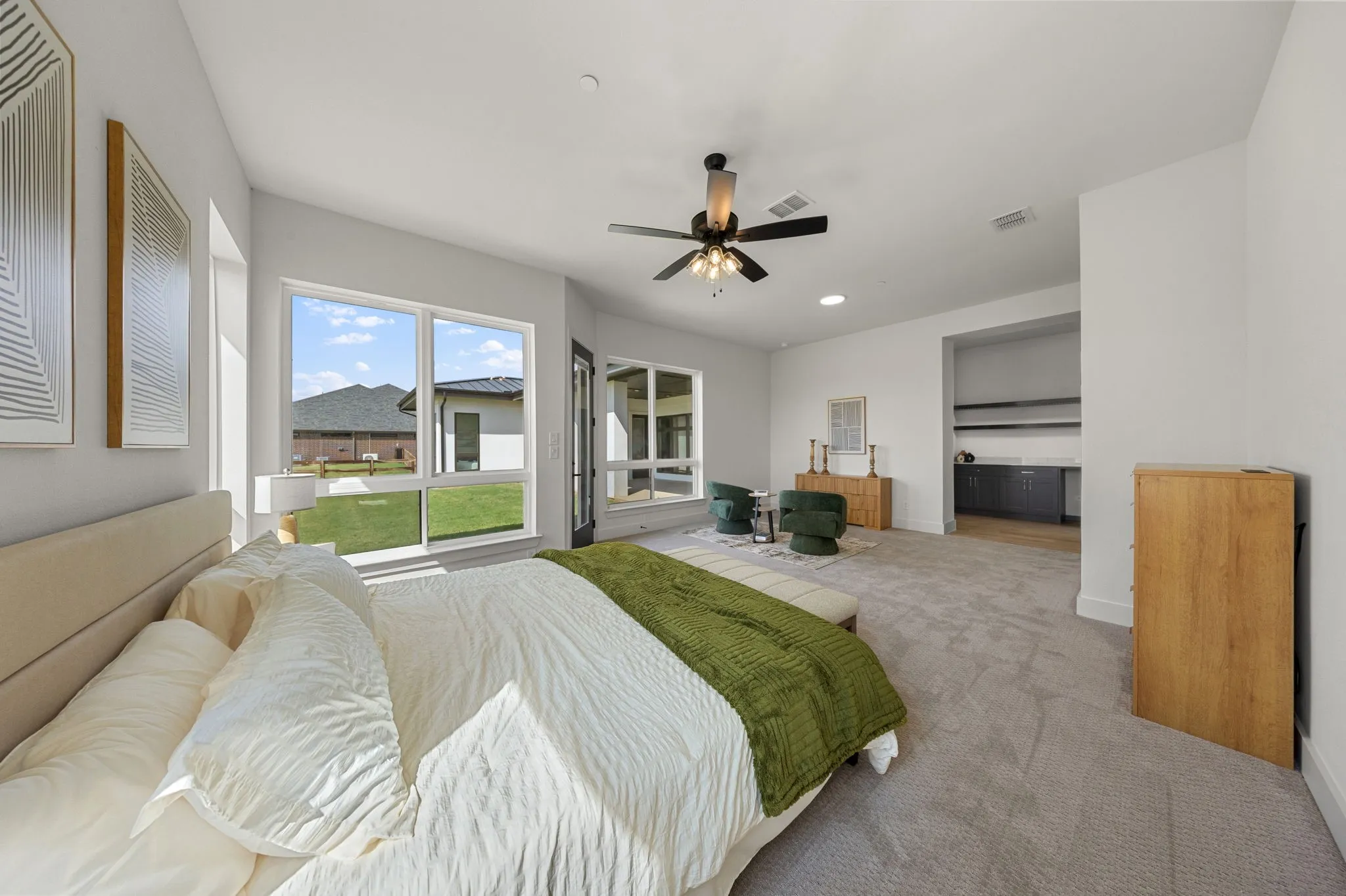 Expansive room with high ceilings, large windows, a built-in wet bar, and a ceiling fan