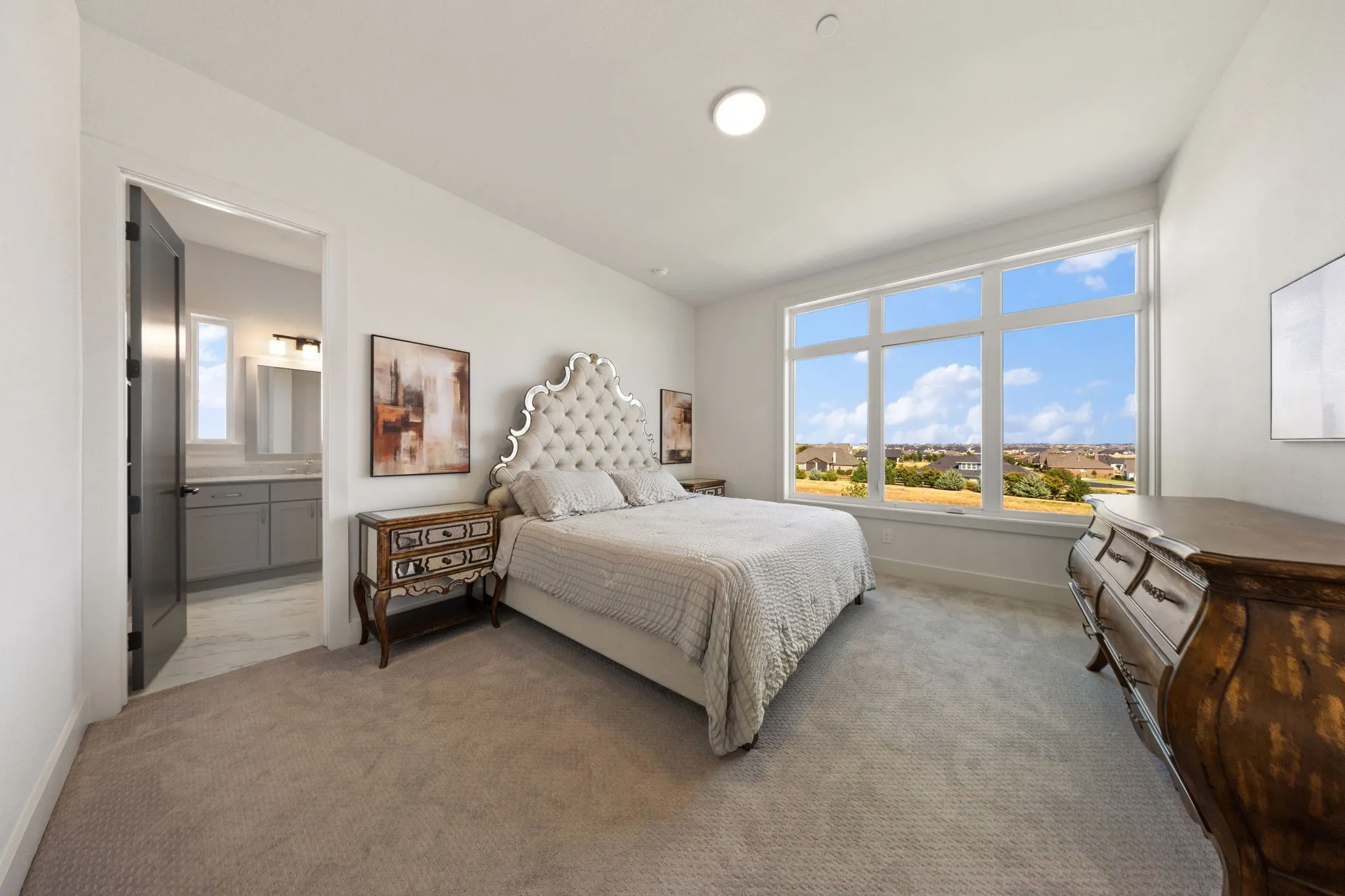 Spacious room with large windows, light gray carpeting, and a dark gray interior door