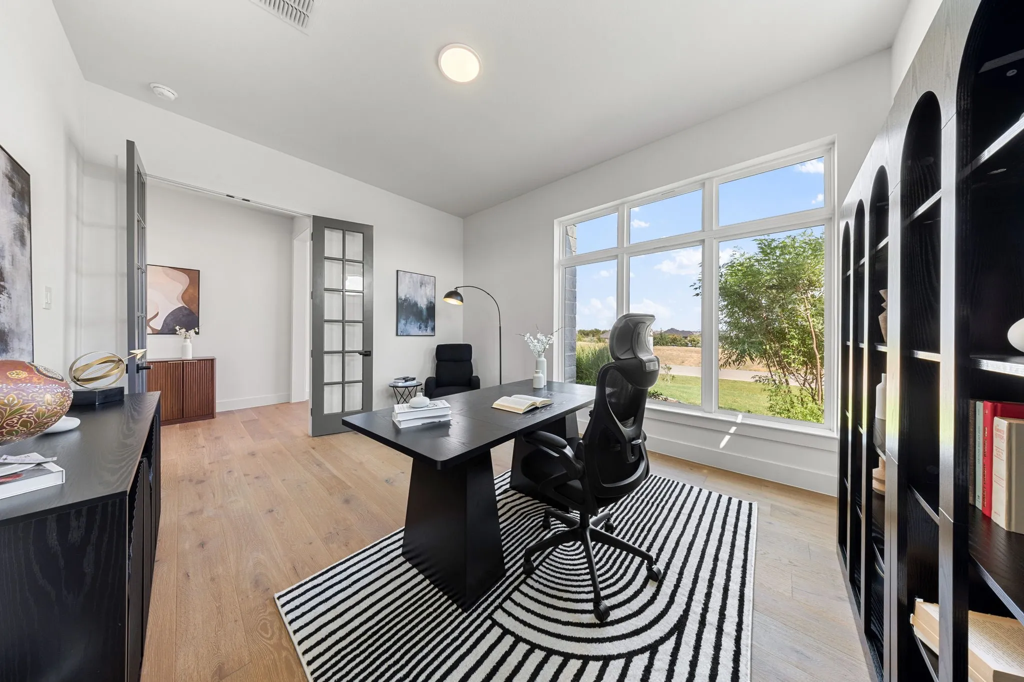 Light wood-finish flooring, recessed lighting, and a large multi-pane window
