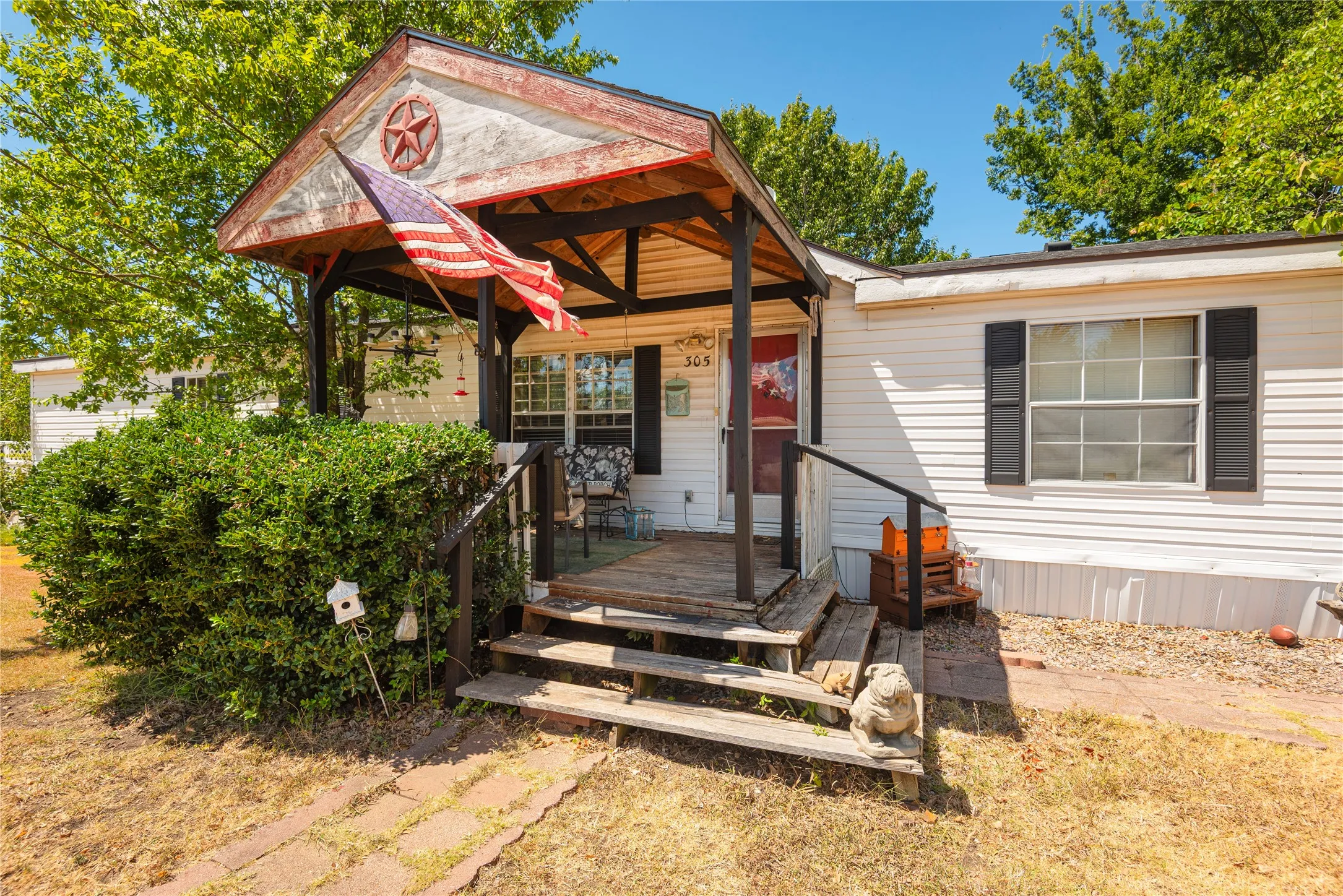 Covered front porch with wood flooring and railing