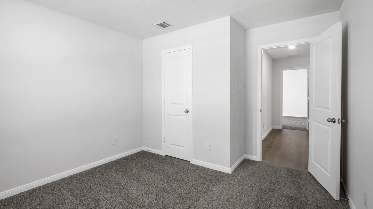 Neutral-toned interior room featuring gray carpet flooring and white baseboards