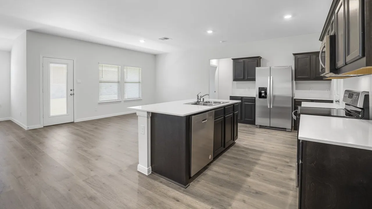 Open concept living area featuring wood-finish flooring, a kitchen island with sink and dishwasher, white countertops, dark wood cabinetry, and stainless steel appliances
