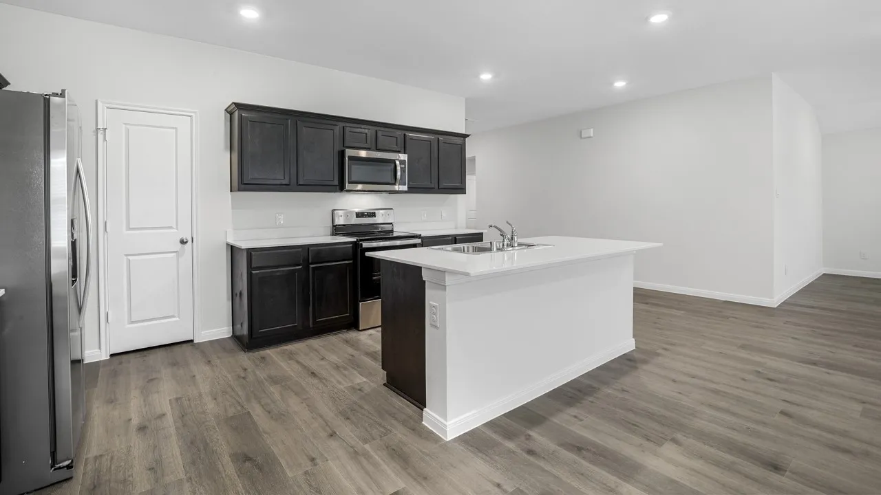 Modern kitchen featuring dark wood cabinetry, stainless steel appliances, a white tile backsplash, and light-toned countertops