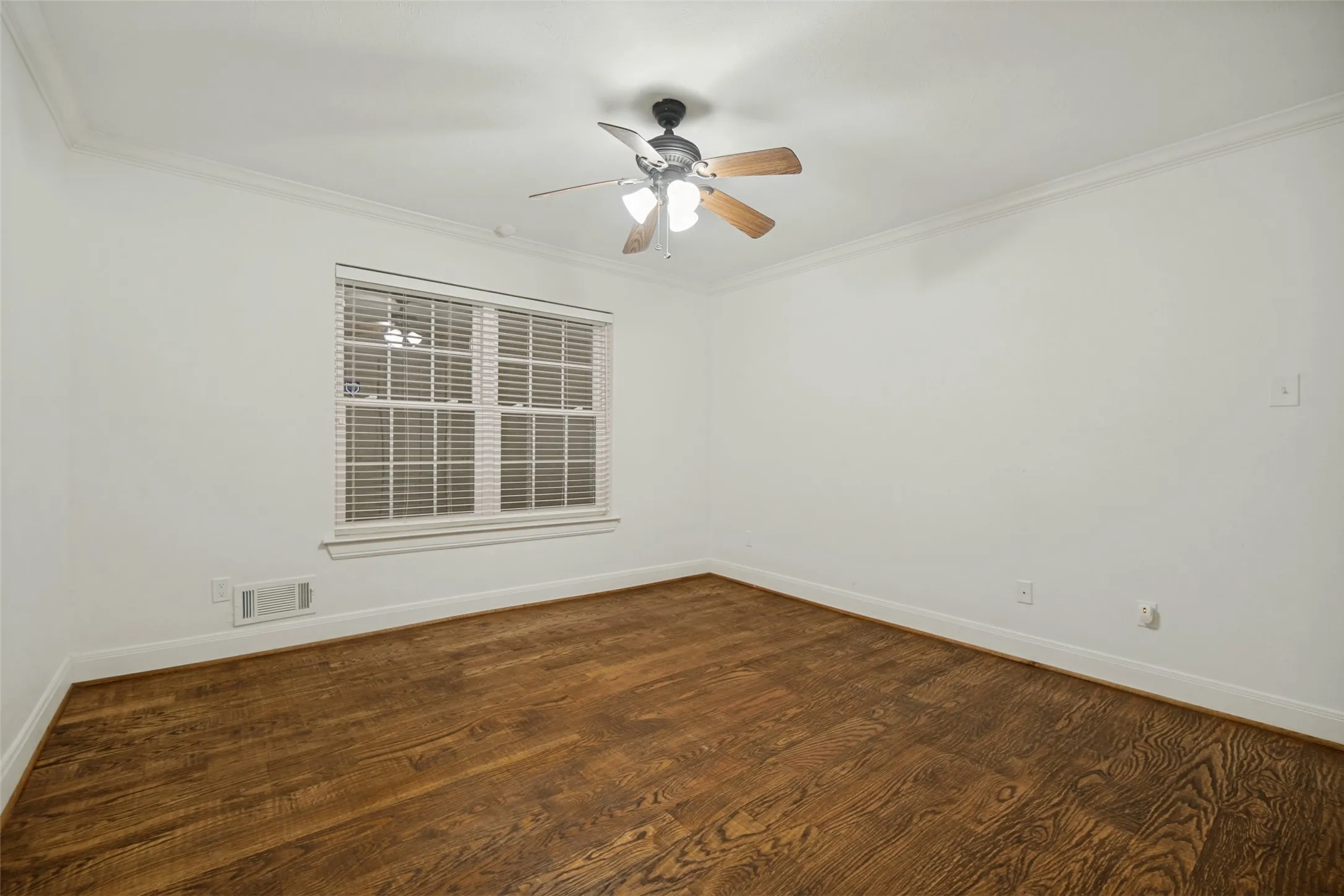 Hardwood flooring, crown molding, double-pane window with blinds, and a ceiling fan with integrated lighting