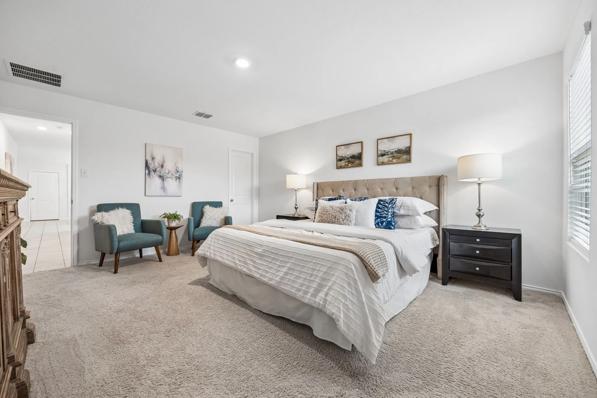 Plush carpet flooring, recessed ceiling lighting, light-toned walls, a window with blinds, and a white door with dark hardware