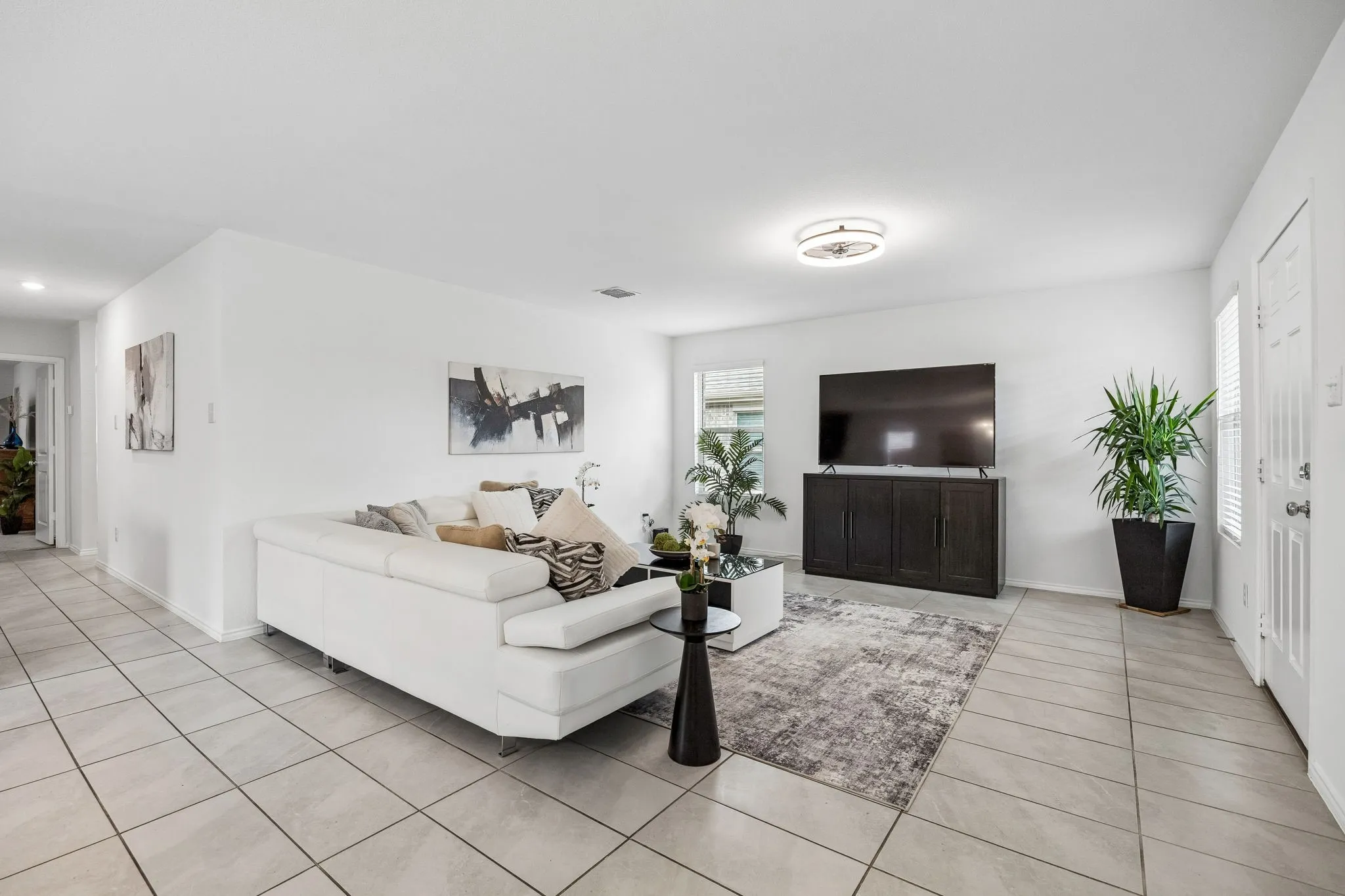 Expansive living area featuring tile flooring, white walls, and recessed lighting