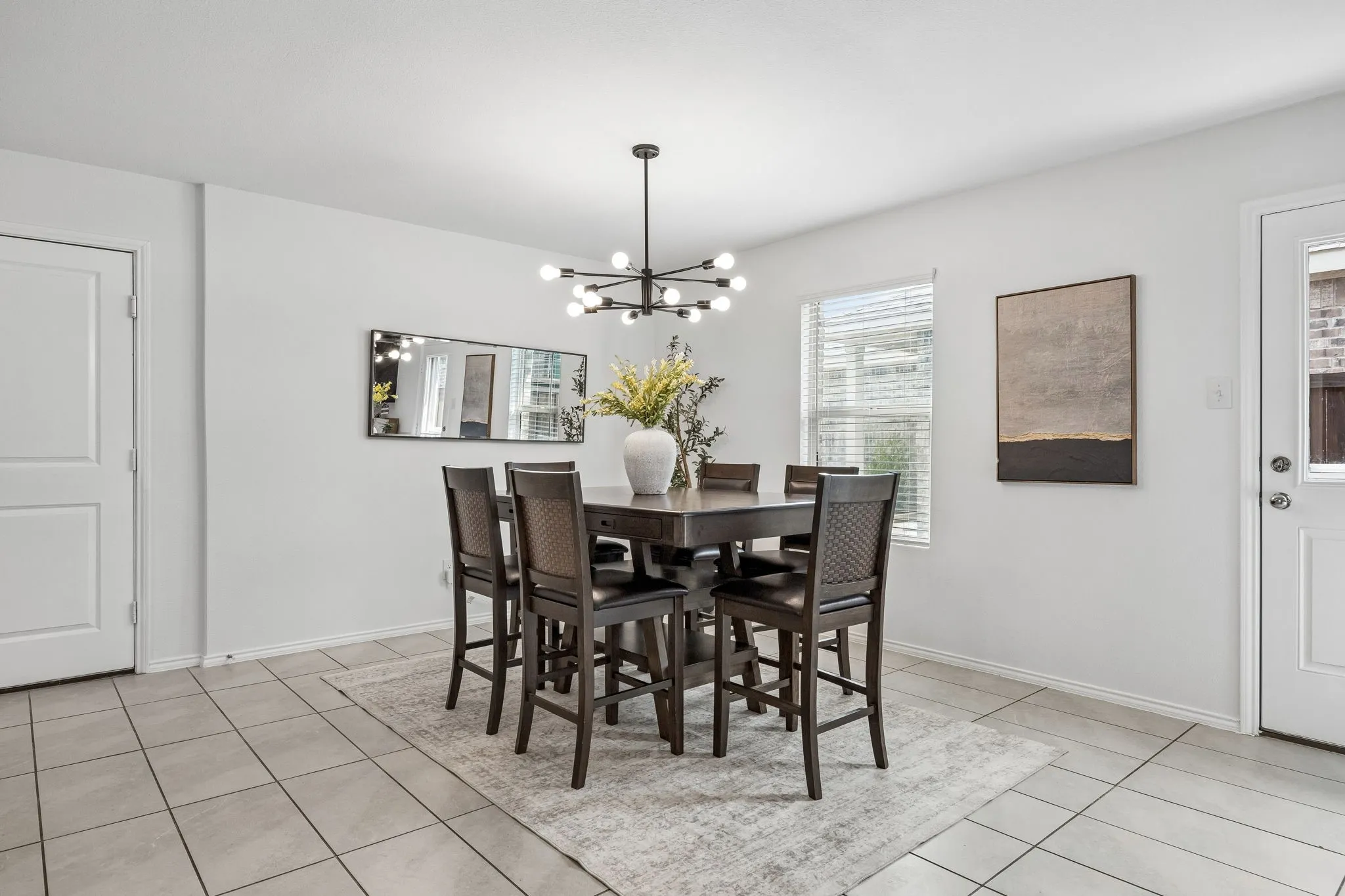 White interior walls, rectangular tiled flooring, modern chandelier, window with blinds, and white panel doors
