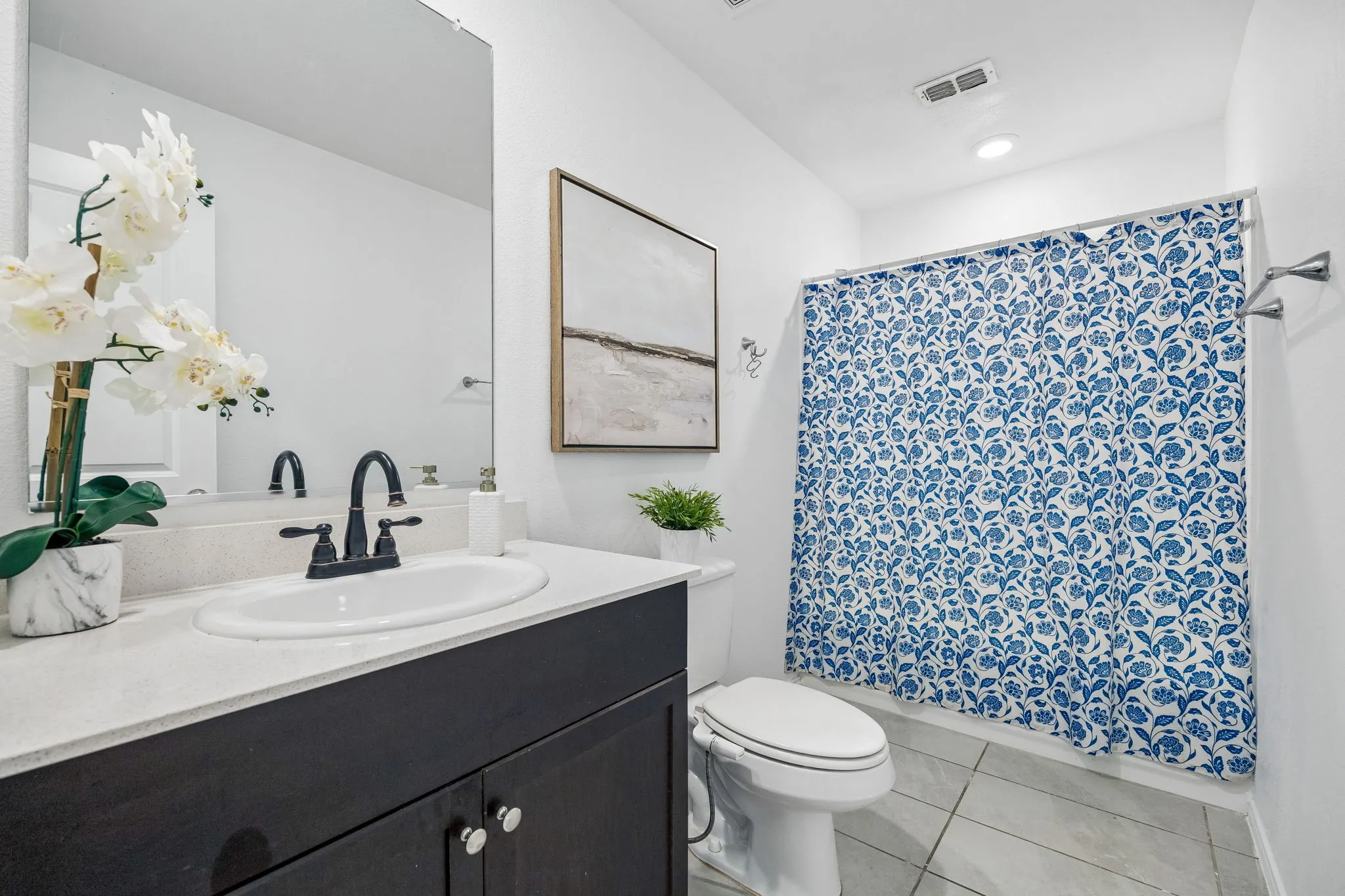 White vanity with a neutral countertop, undermount sink, and matte black faucet