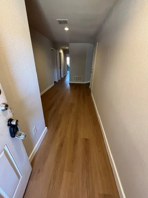 Wood-finish flooring throughout, recessed ceiling lighting, and white trim