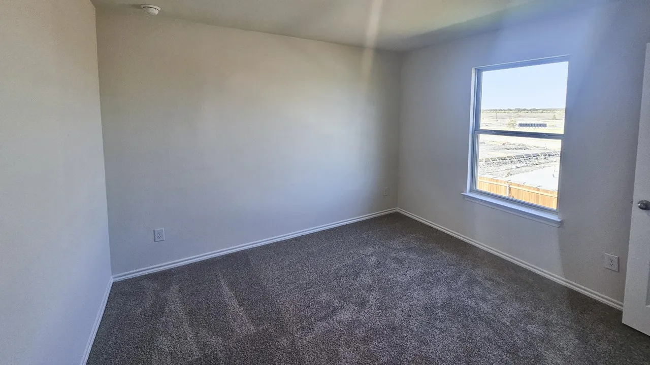 Room with light gray wall paint, gray carpet, and a double-hung window
