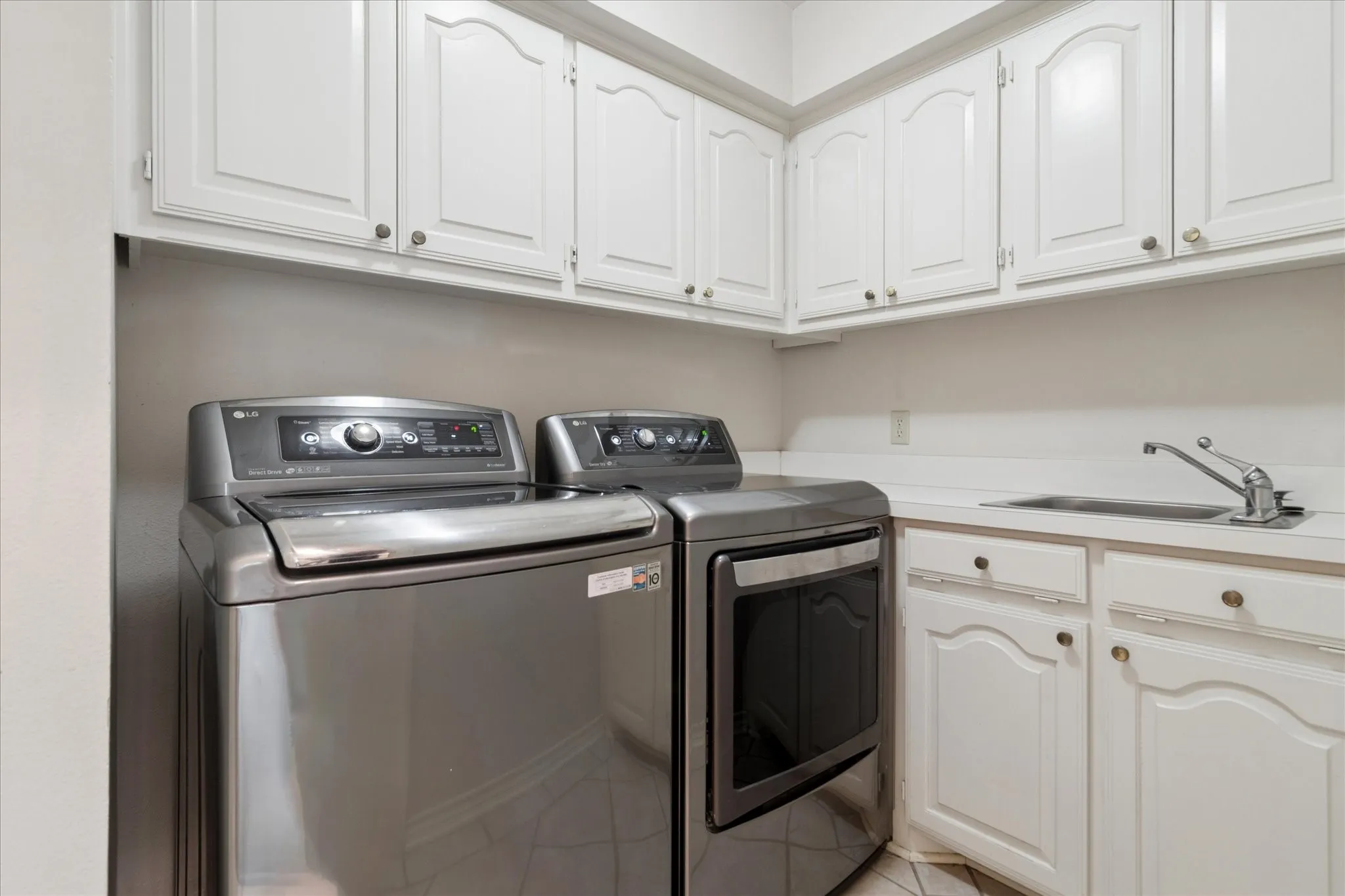 Laundry room includes sink and built-in cabinets