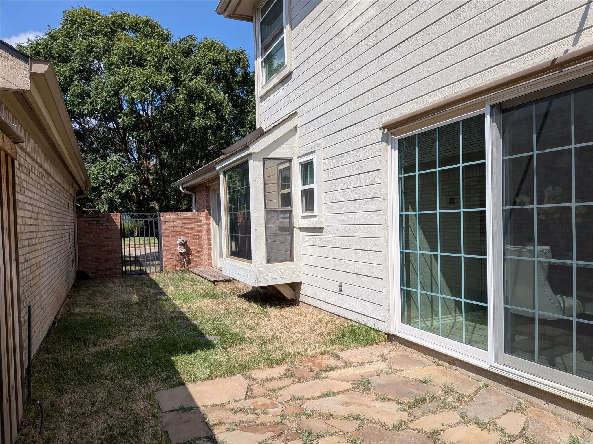 Side yard is accessible from kitchen and breakfast room as well as primary bedroom.
