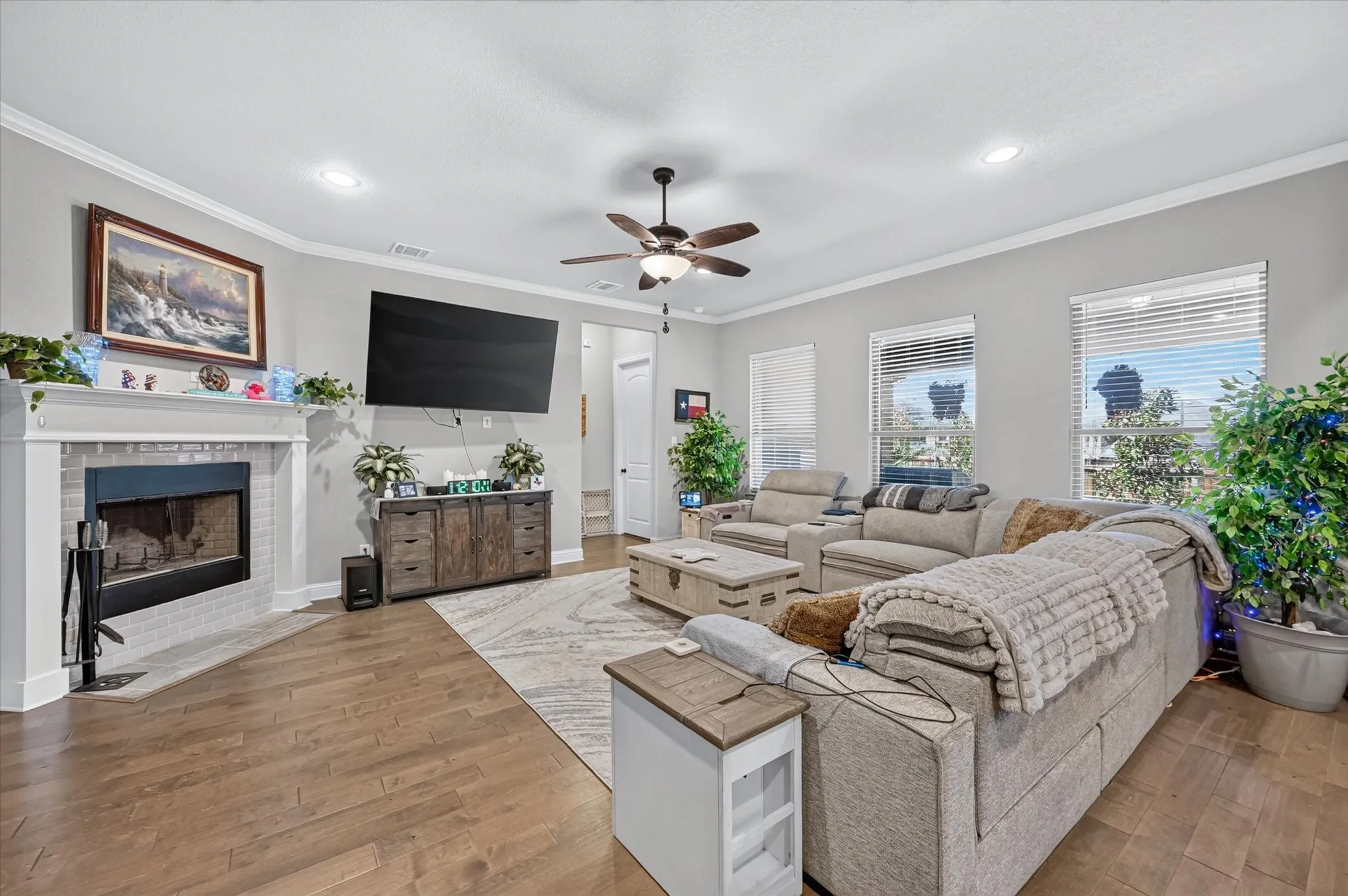 Hardwood-finish flooring, recessed lighting, ceiling fan, and a tiled fireplace with mantel