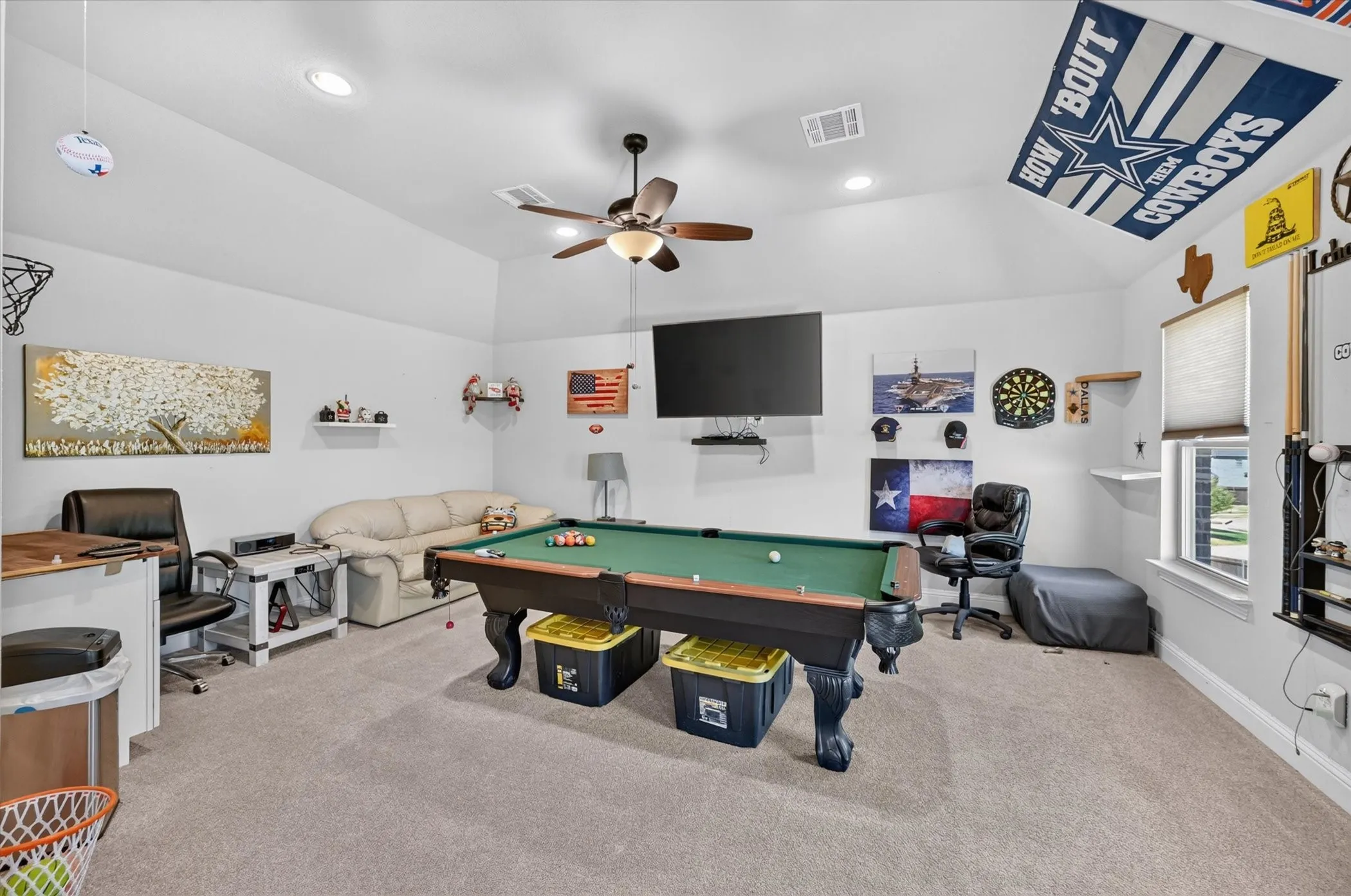 Spacious room with sloped ceilings, recessed lighting, and a ceiling fan