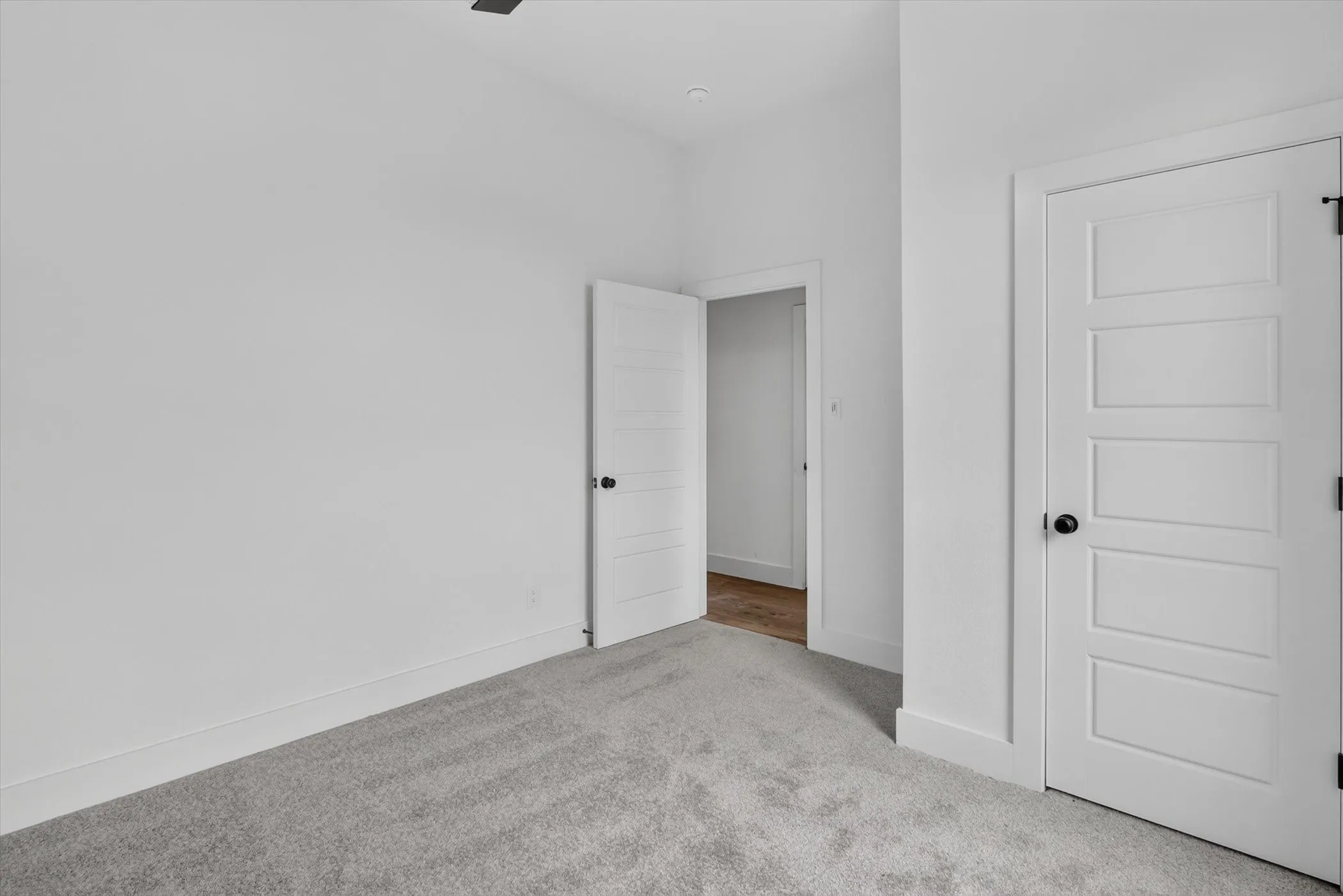 Crisp white walls with contrasting dark hardware and trim