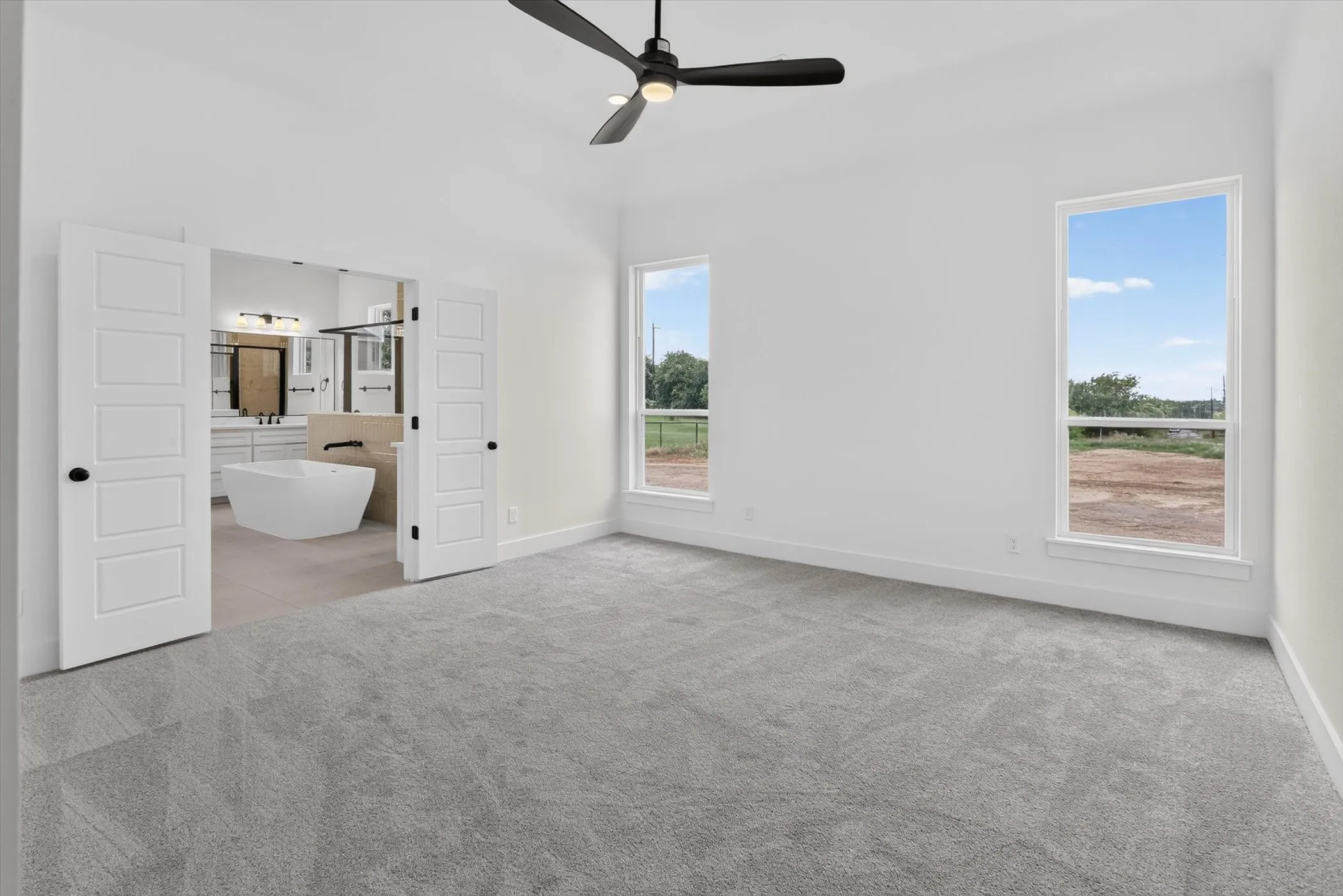 Spacious room featuring light gray carpeting and white walls