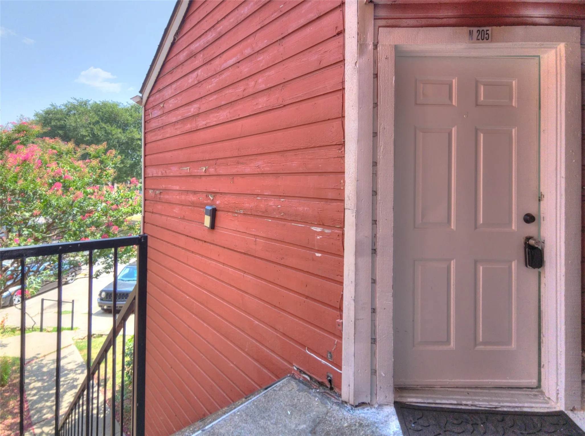 Red horizontal siding exterior with a white paneled entry door