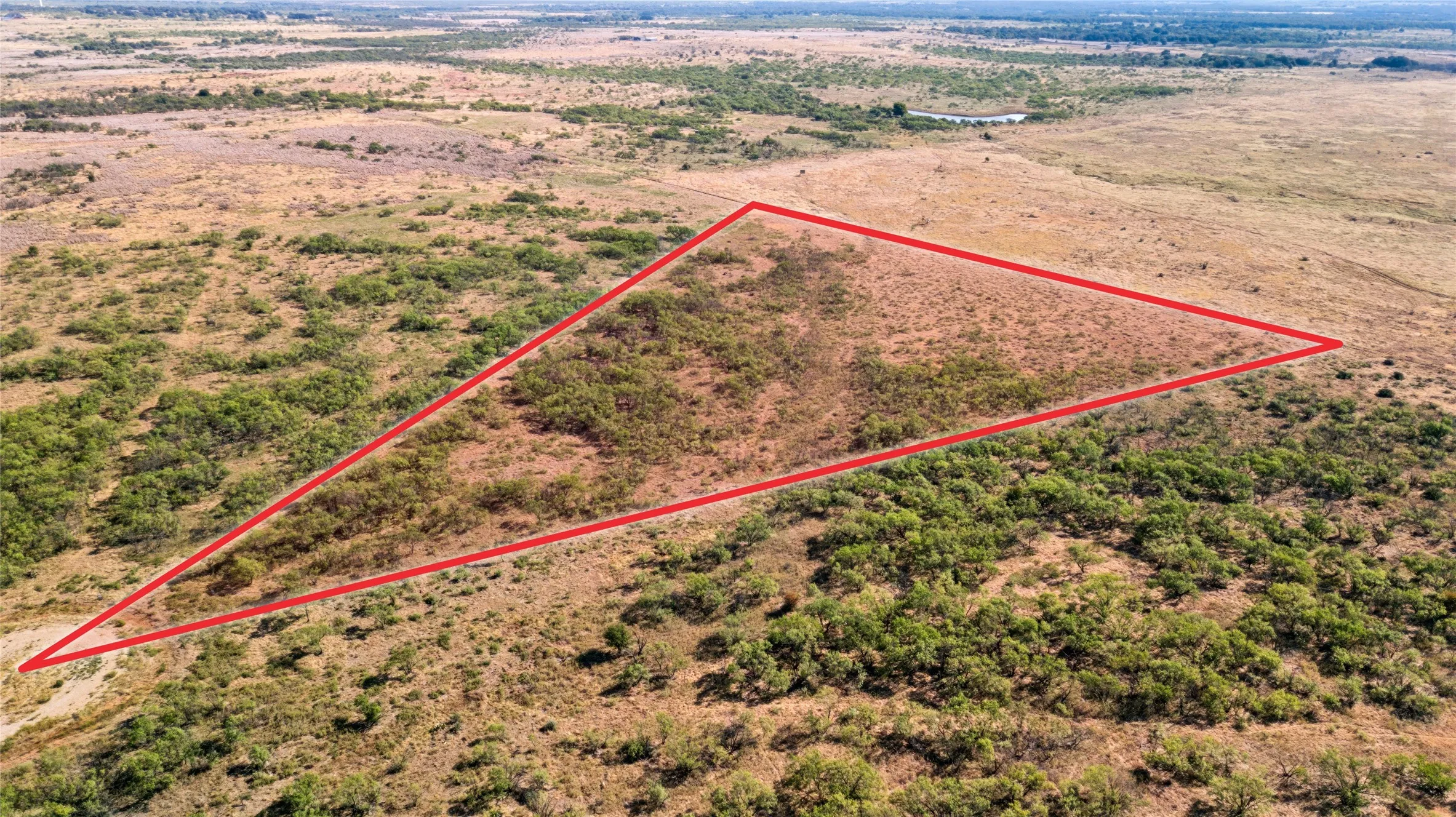 Expansive land parcel featuring natural terrain and sparse vegetation