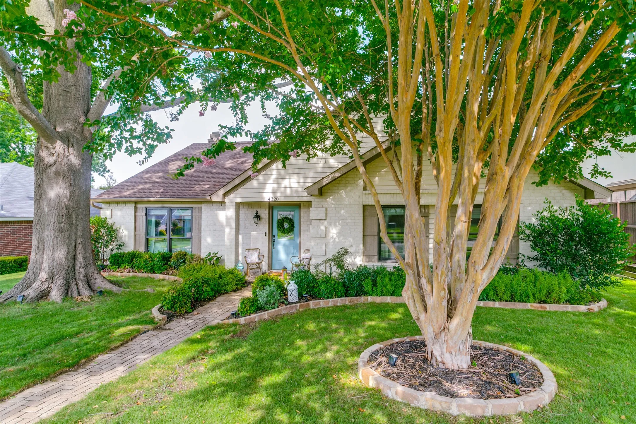 This charming home boasts incredible curb appeal with freshly painted brick, a beautiful glass front door, shutters on the windows & meticulously landscaped flower beds.