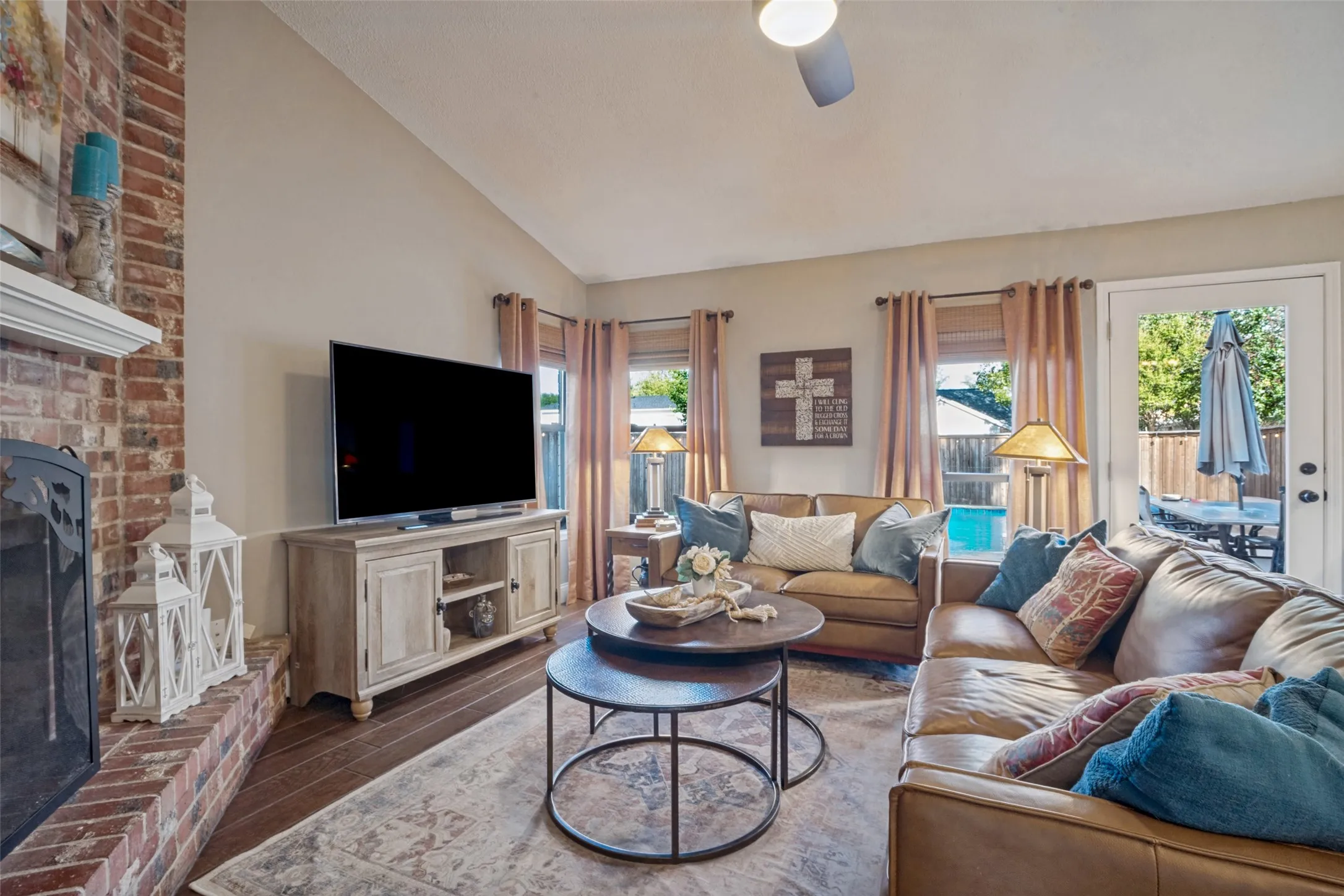The cozy casual living room features a brick fireplace, tile floor & a wall for your entertainment center.