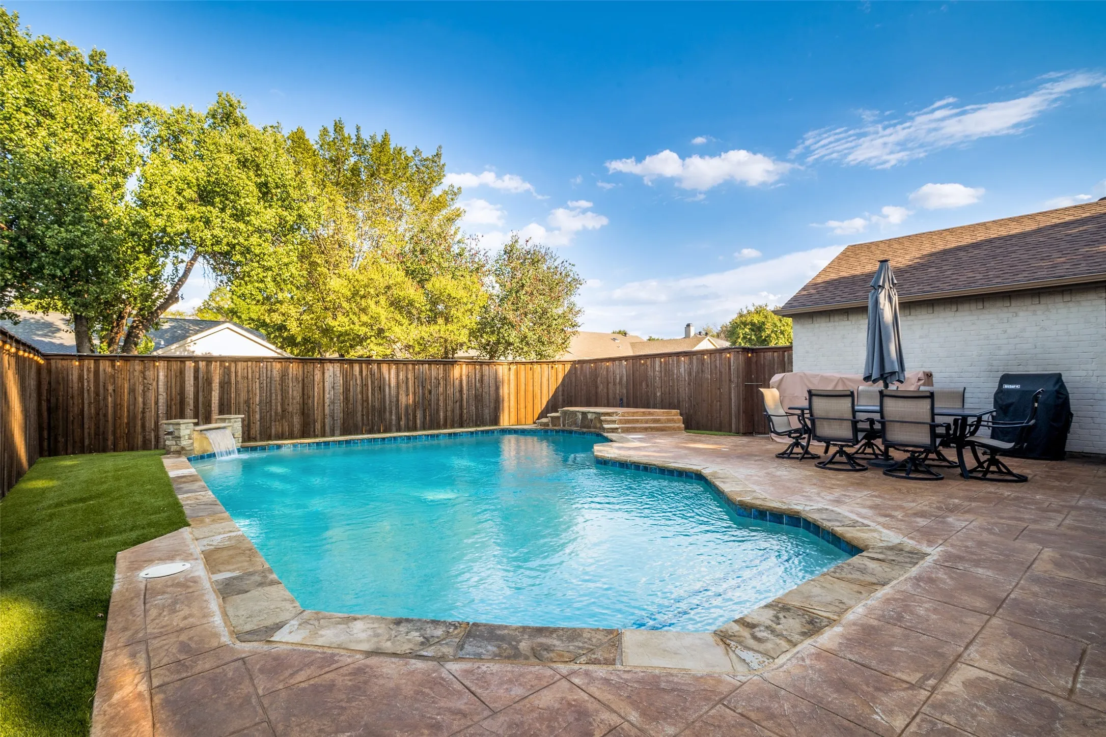 The backyard retreat features a sparking swimming pool with a water feature.  Entertain a large gathering of friends and family on the expansive patio space!