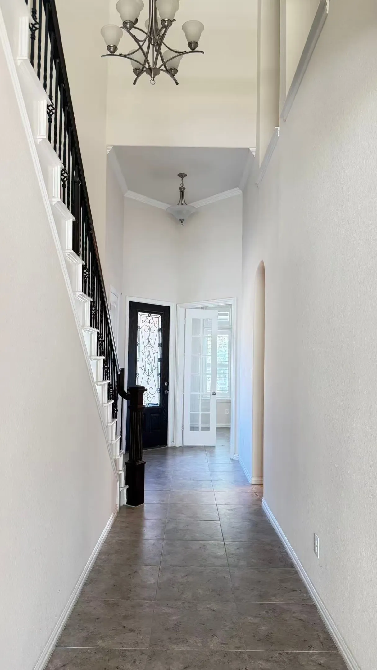 Welcoming foyer featuring a wood-finish plank floor, clean white walls, and a decorative ceiling fixture