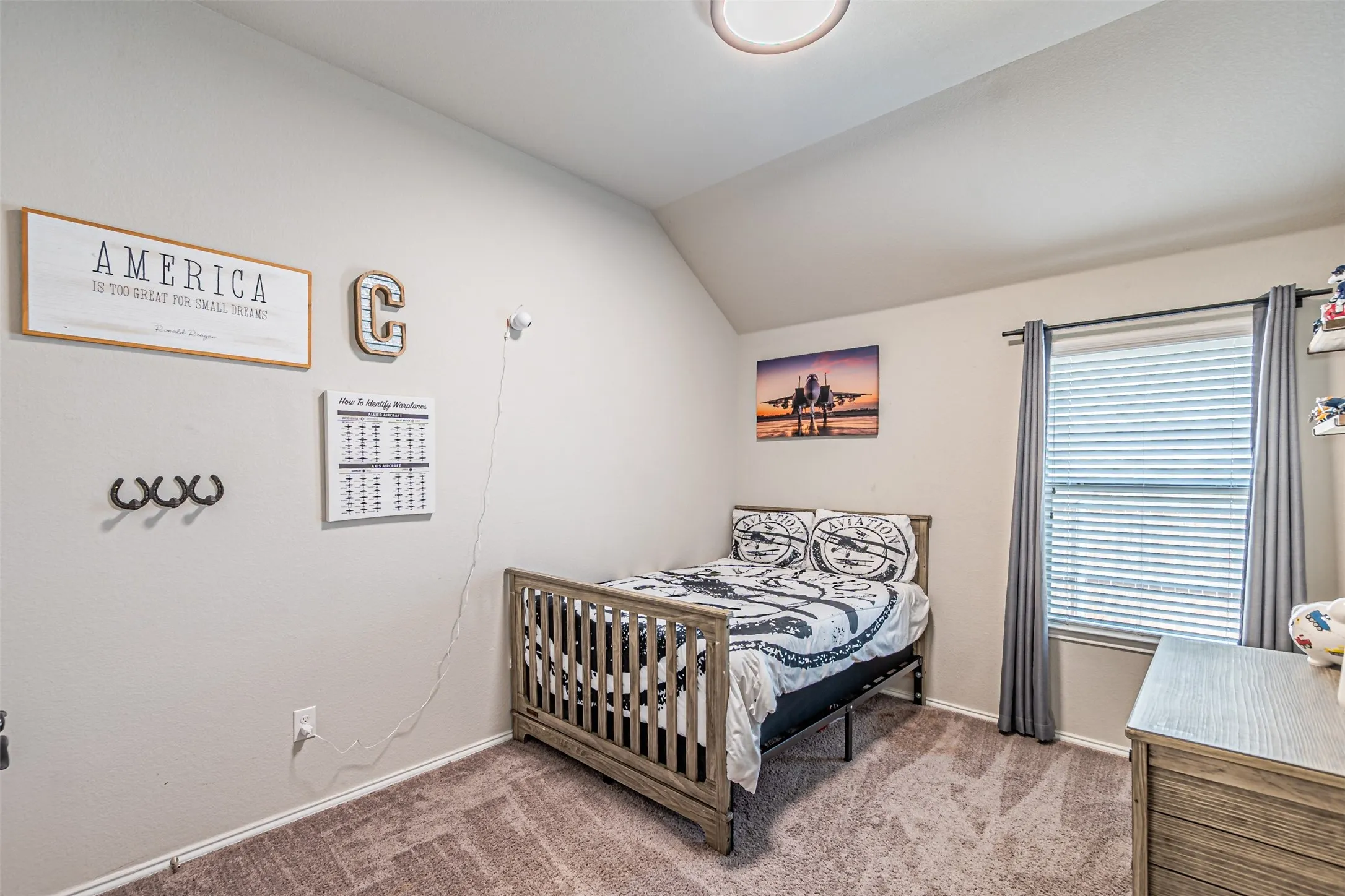 Bedroom featuring vaulted ceiling and light colored carpet