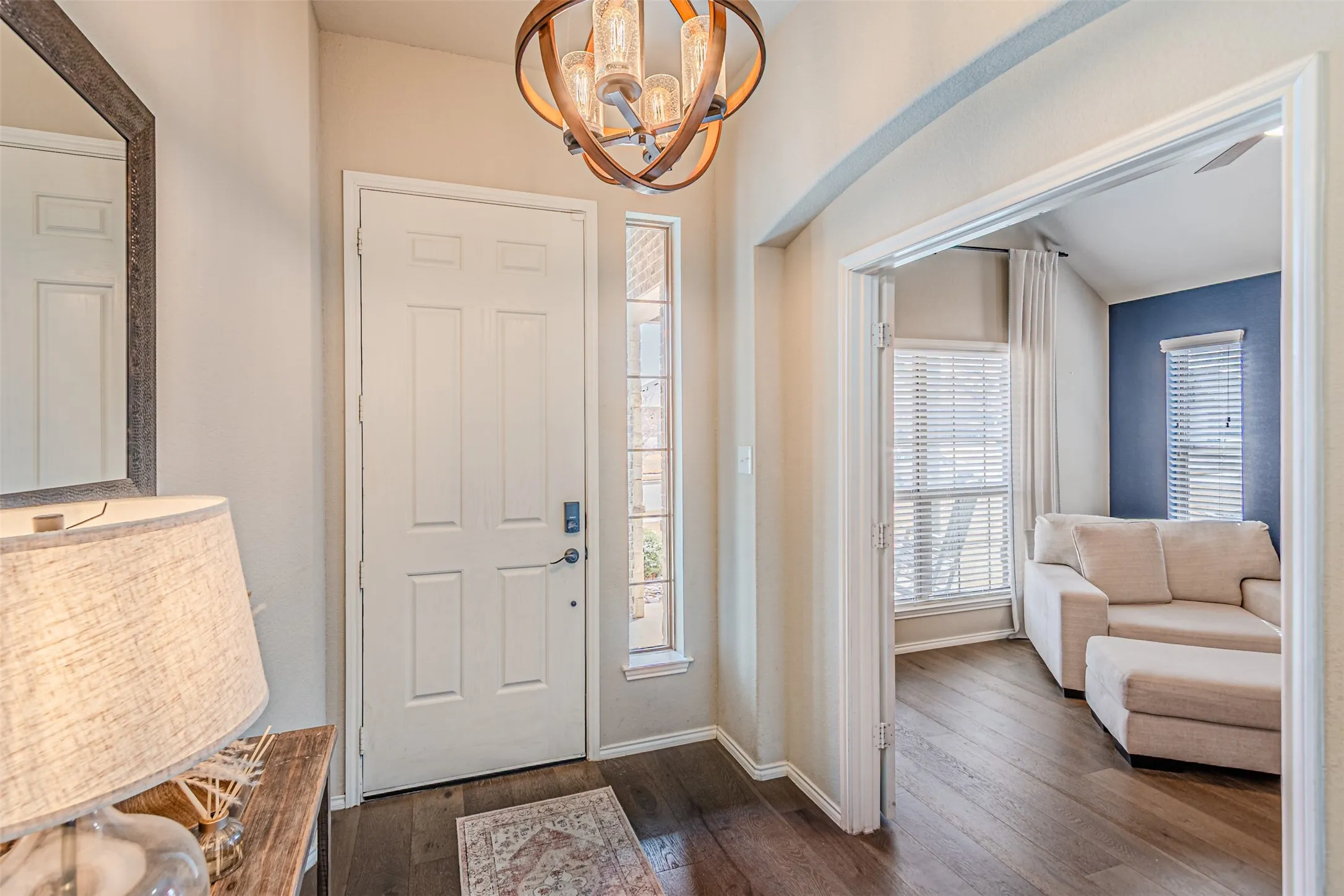 Foyer with dark wood-style flooring and a chandelier