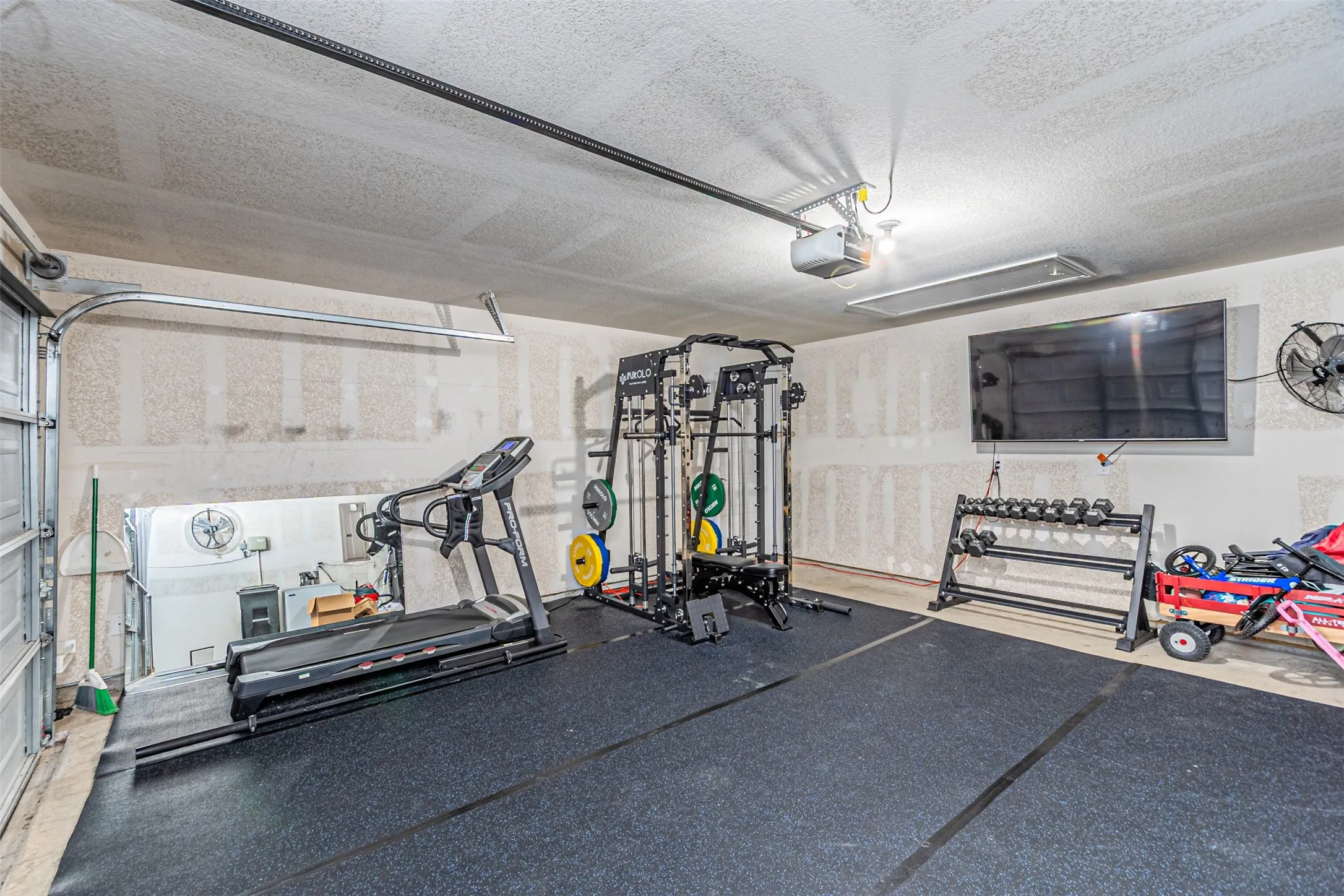 Workout room with a garage and a textured ceiling