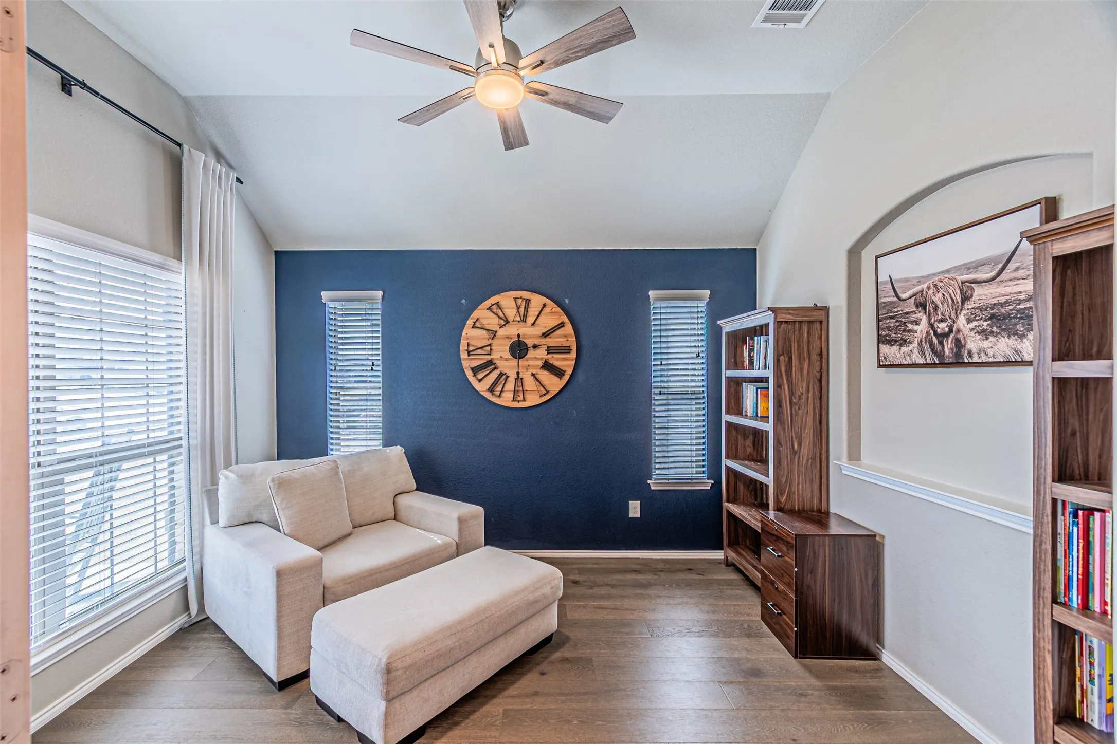 Sitting room featuring vaulted ceiling, wood-type flooring, and a ceiling fan