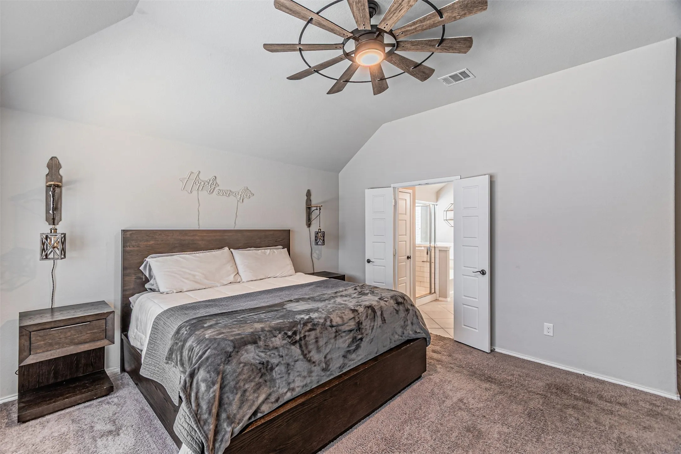 Carpeted bedroom with vaulted ceiling and ceiling fan