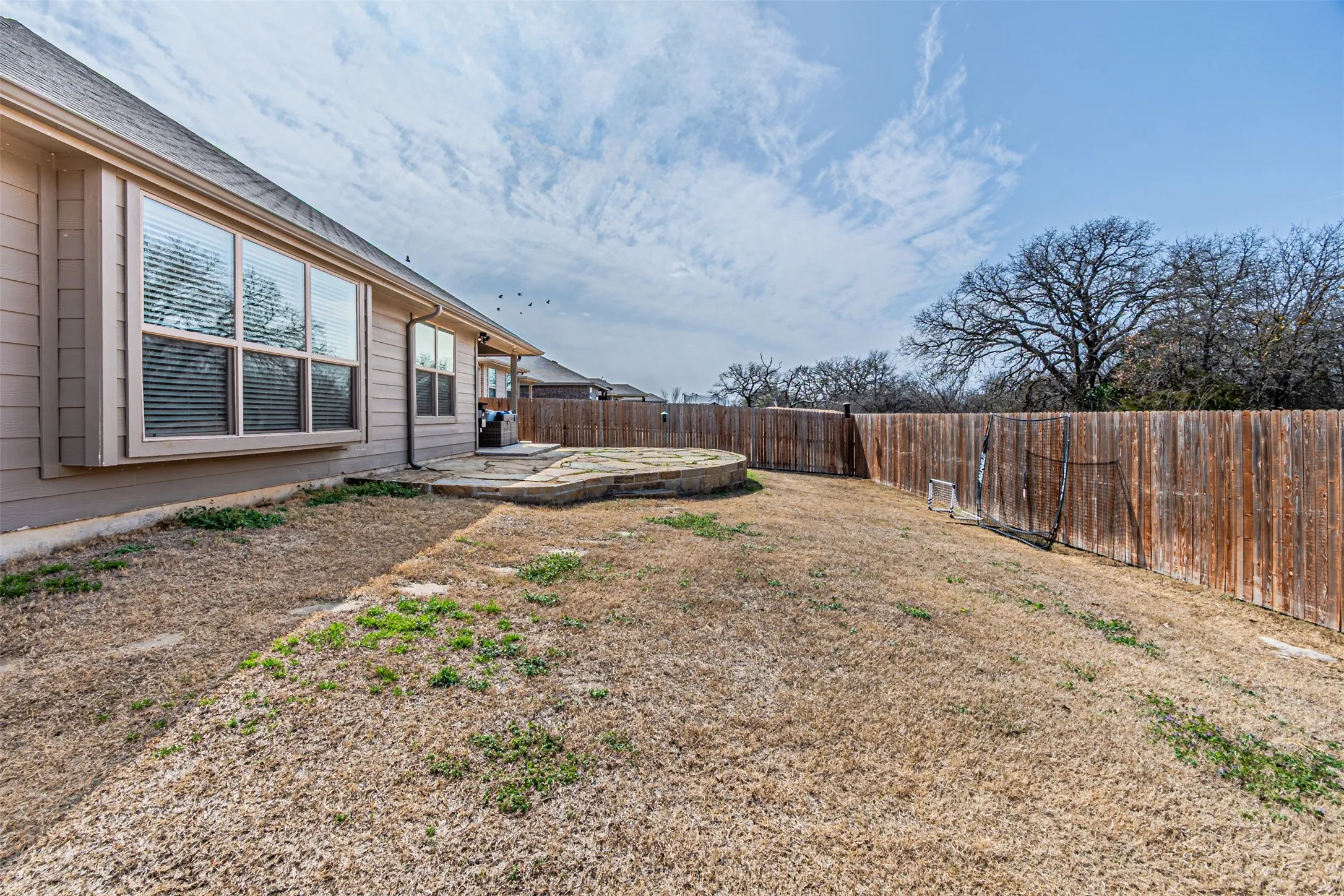Fenced backyard with a patio area