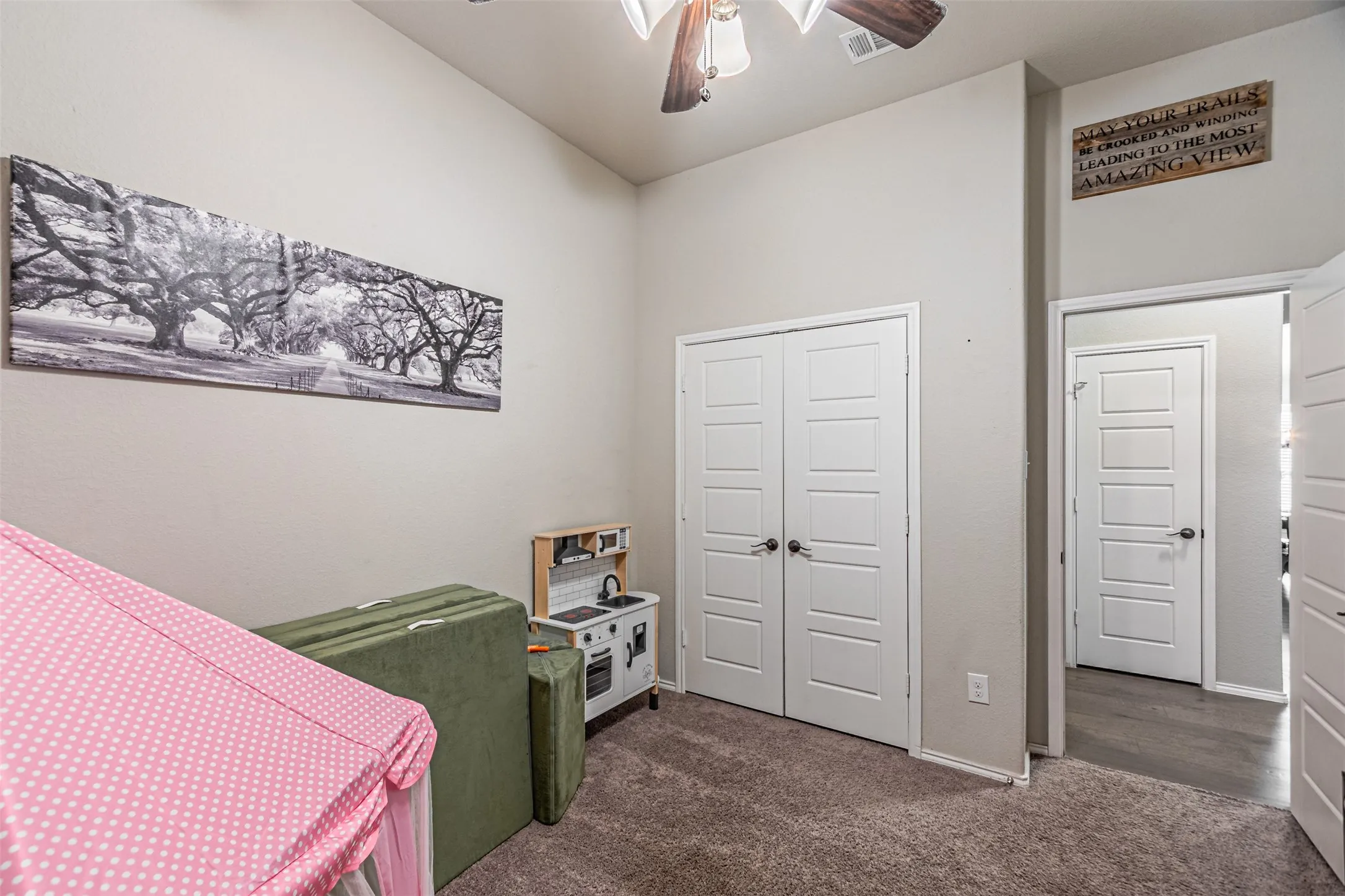 Bedroom featuring dark colored carpet, a closet, and a ceiling fan