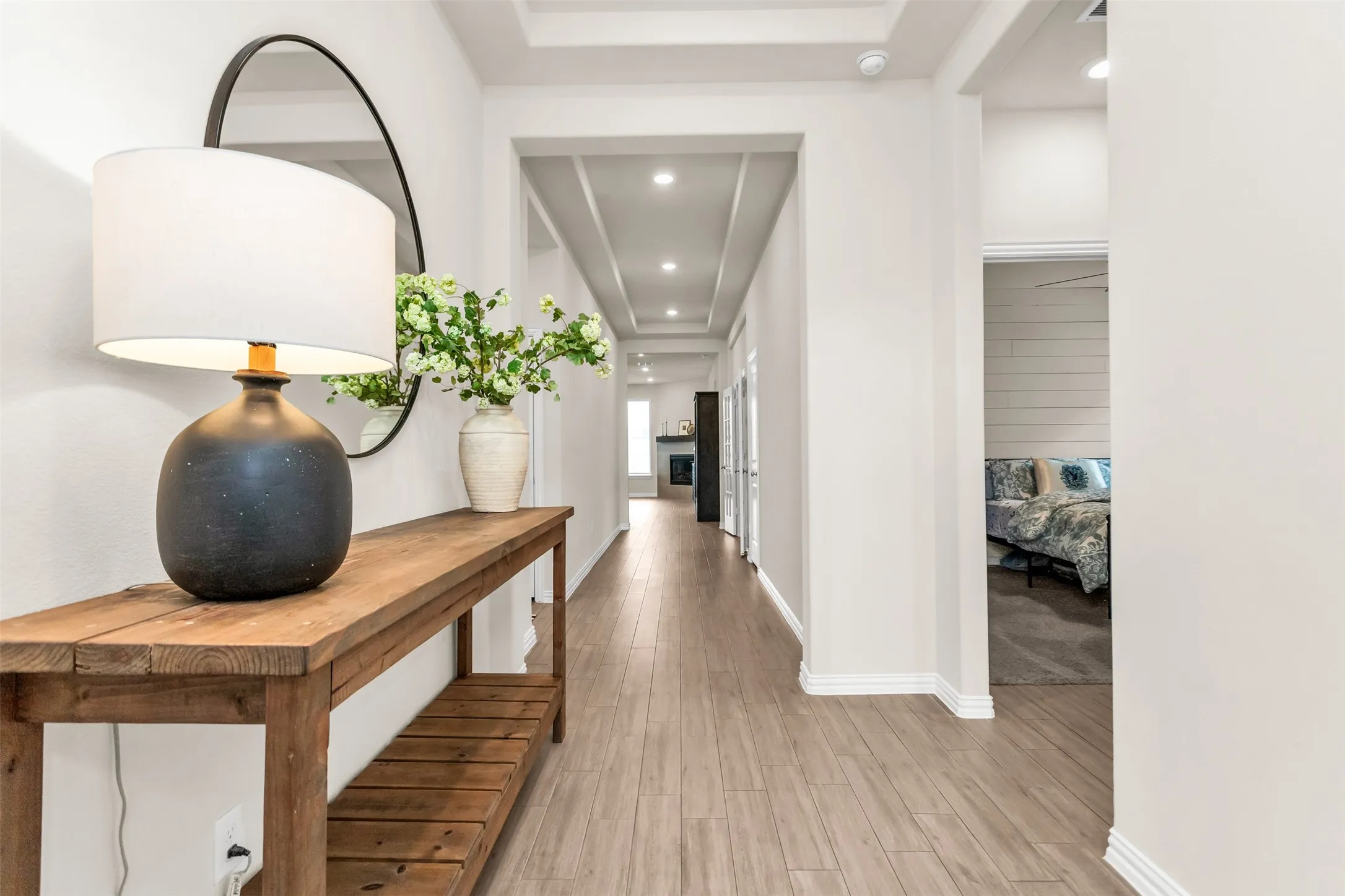 Wood-finish flooring throughout, recessed lighting, and a coffered ceiling feature