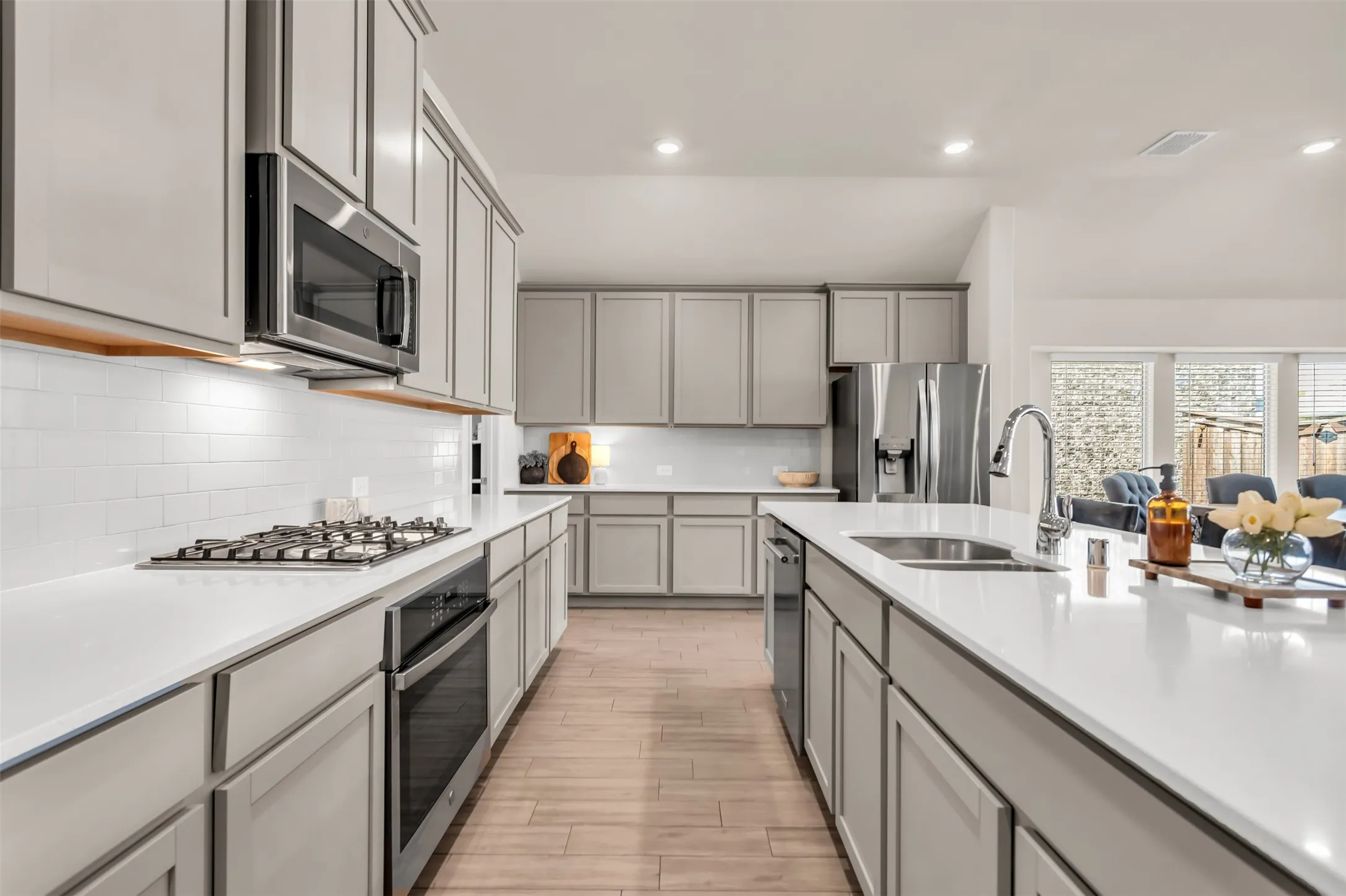 Kitchen featuring light gray cabinetry, white countertops, stainless steel appliances, and a gas cooktop