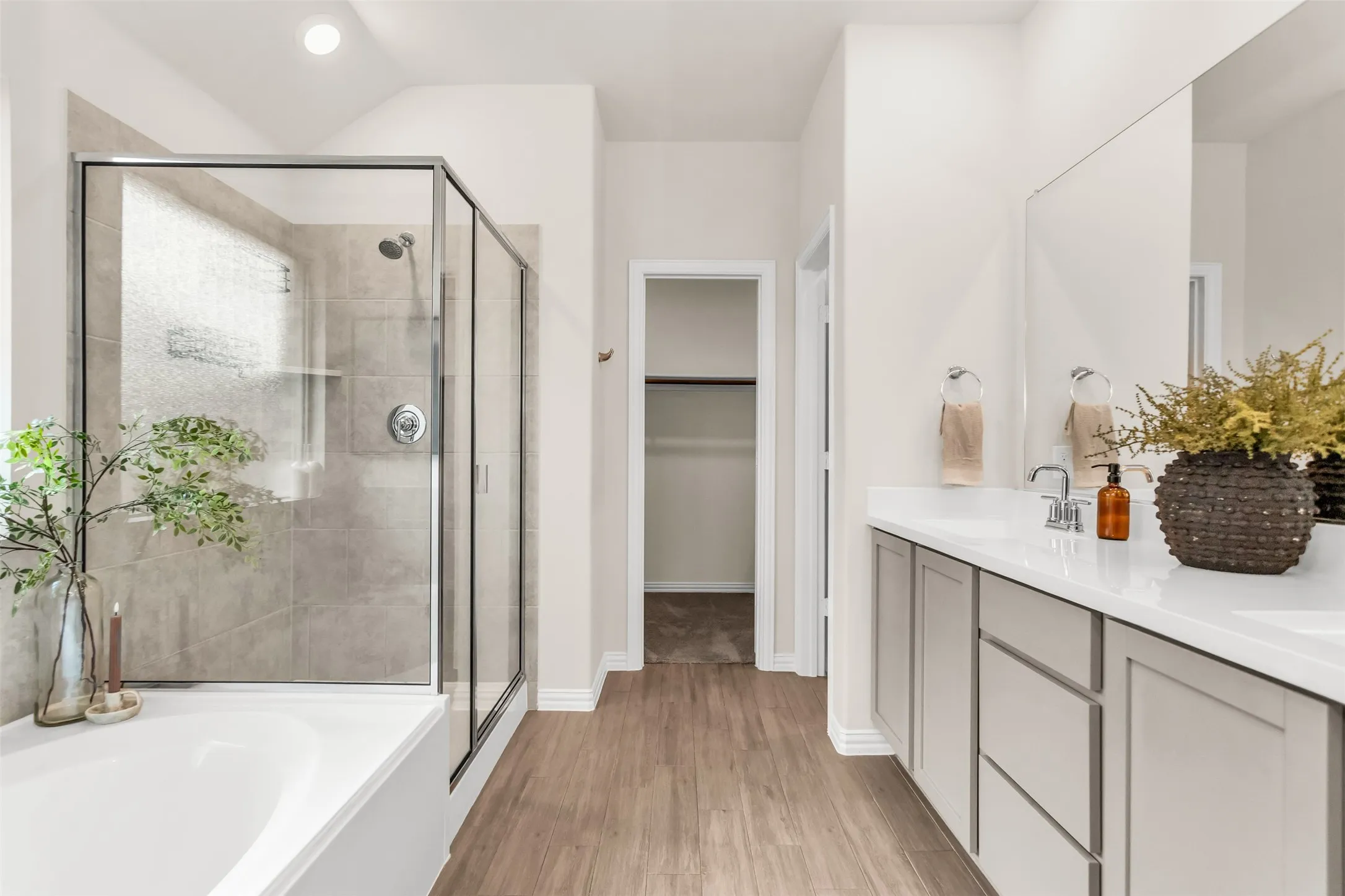 Walk-in shower with clear glass enclosure and tile surround