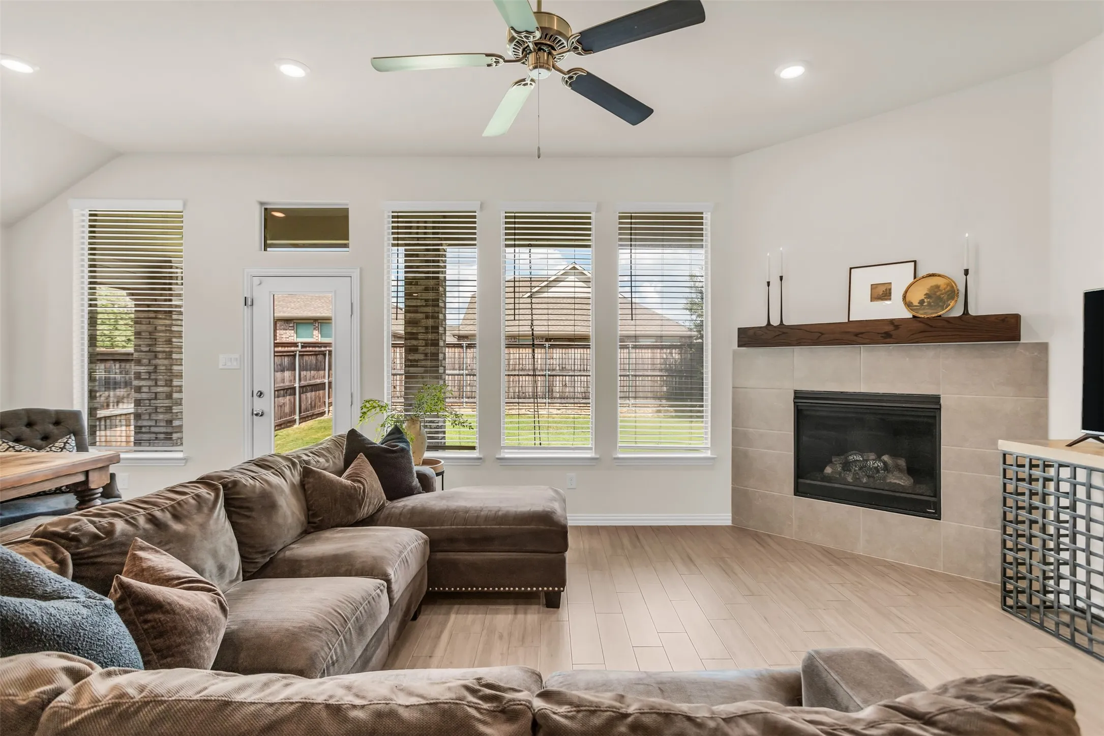 Spacious living area featuring wood-finish flooring and multiple windows