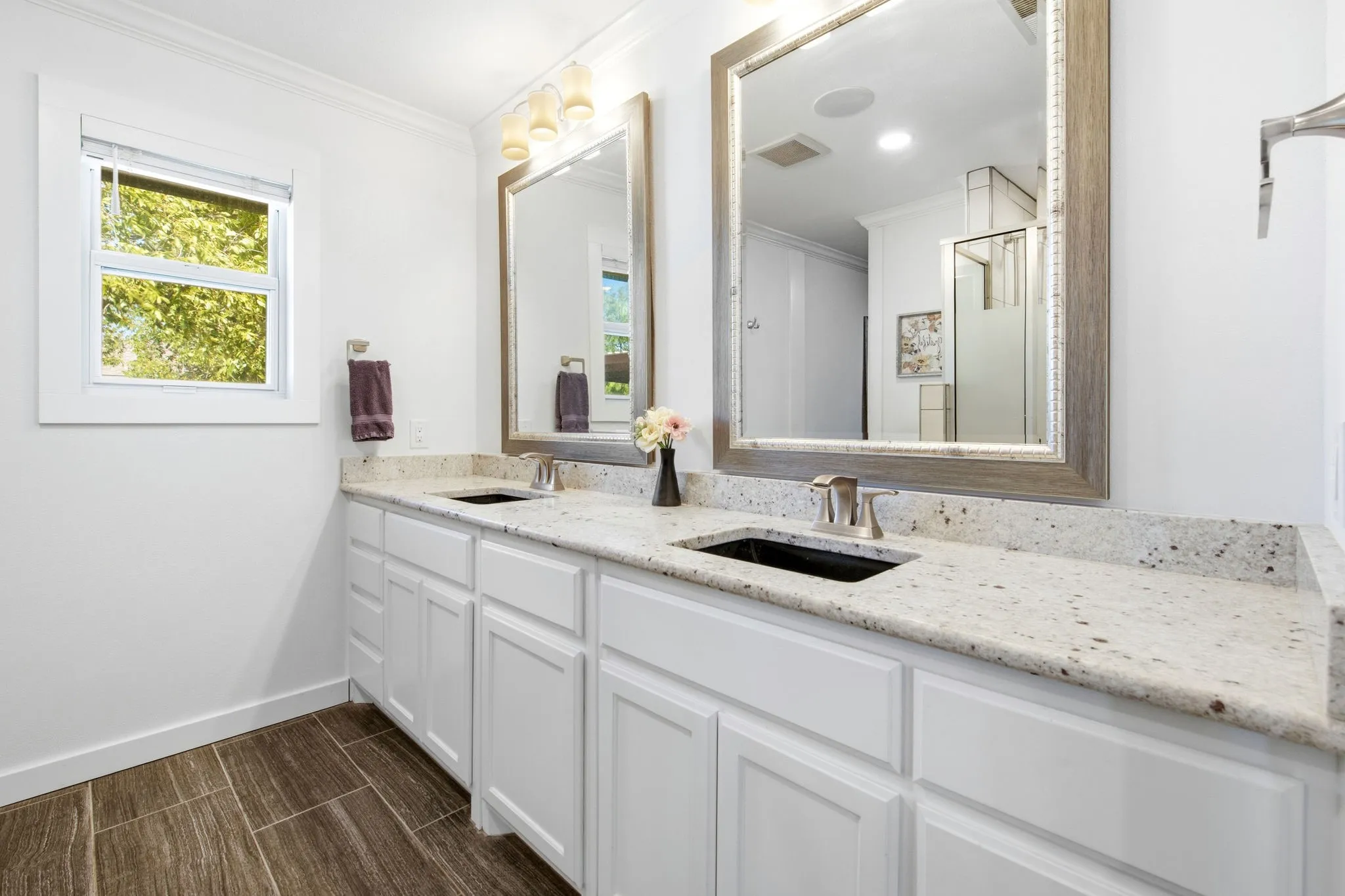 Dual vanity with white cabinetry and light-toned granite countertops