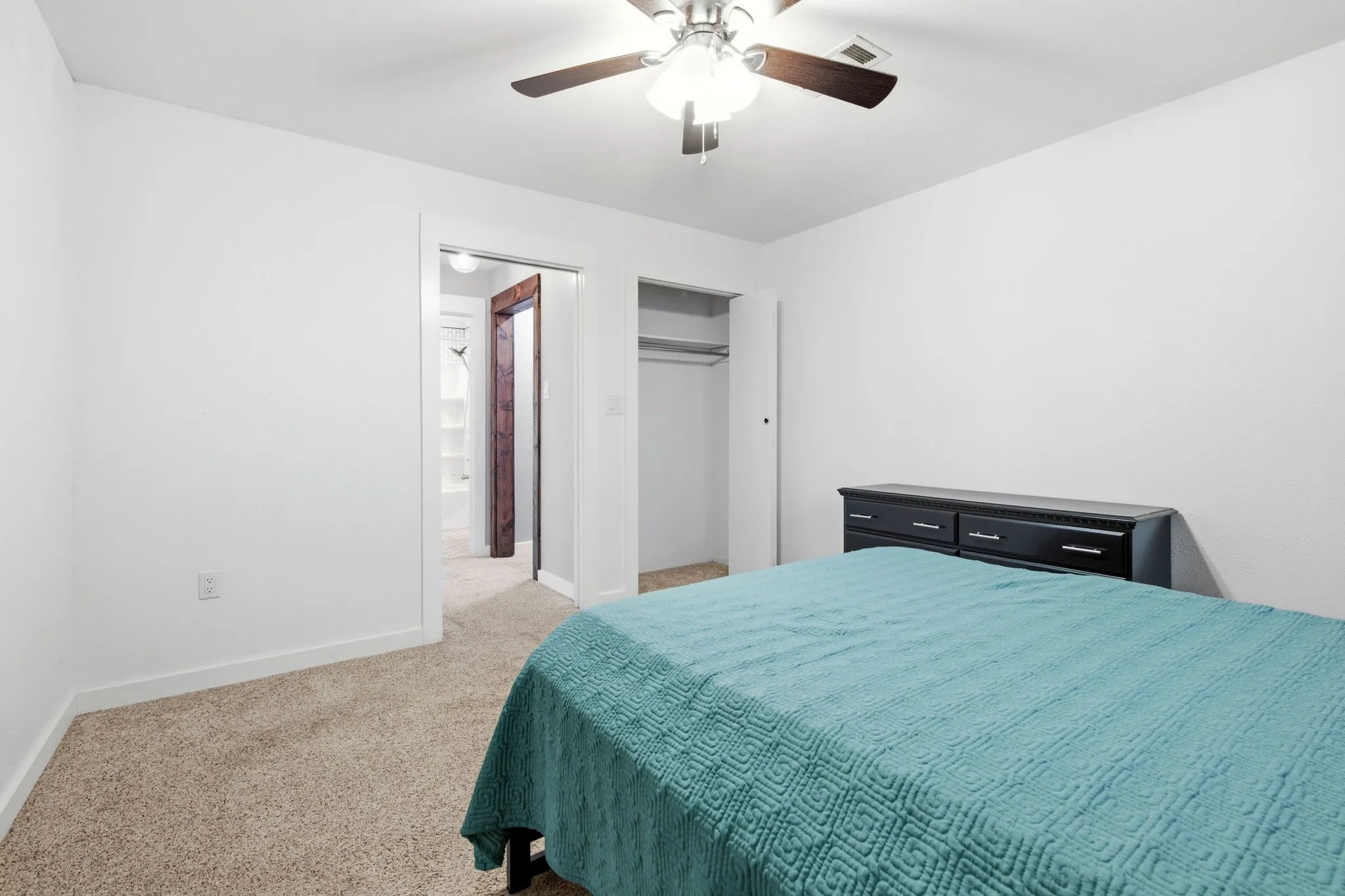 Carpeted  bedroom room featuring white walls, a ceiling fan, and closet