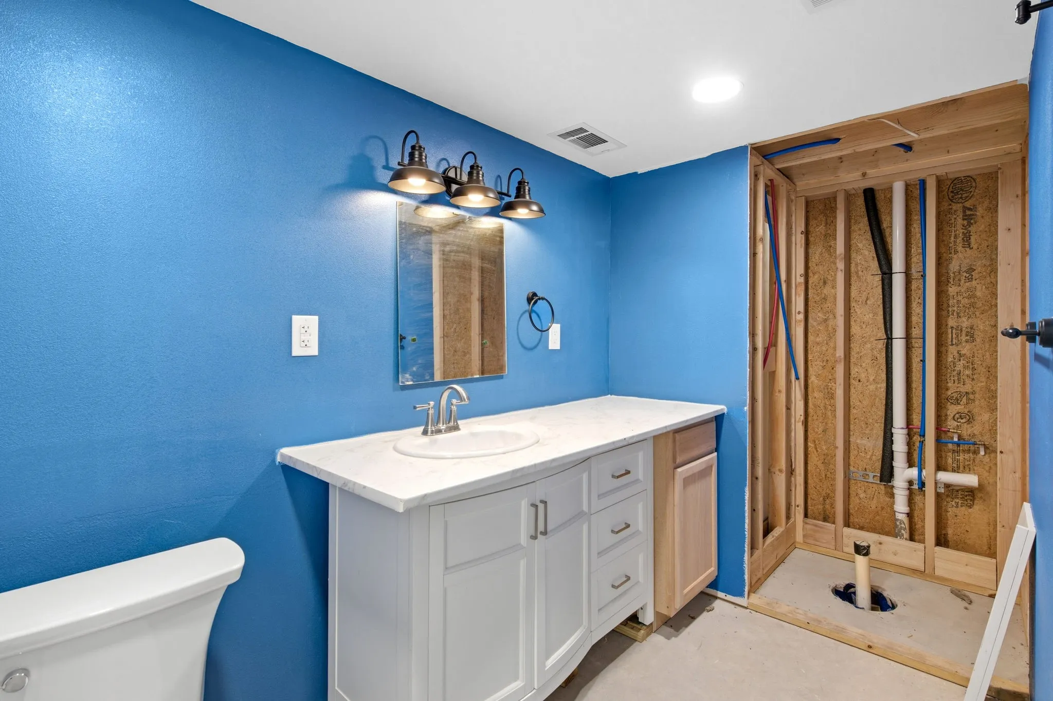 Inside workship bathroom with vanity with white cabinetry, integrated sink, and white countertop