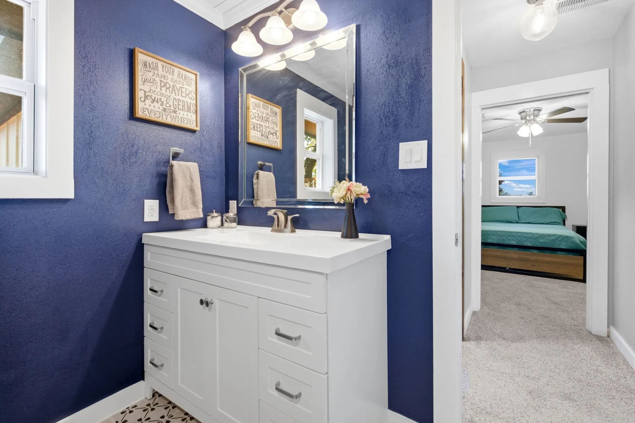 White vanity with brushed nickel hardware, white countertop, and integrated sink