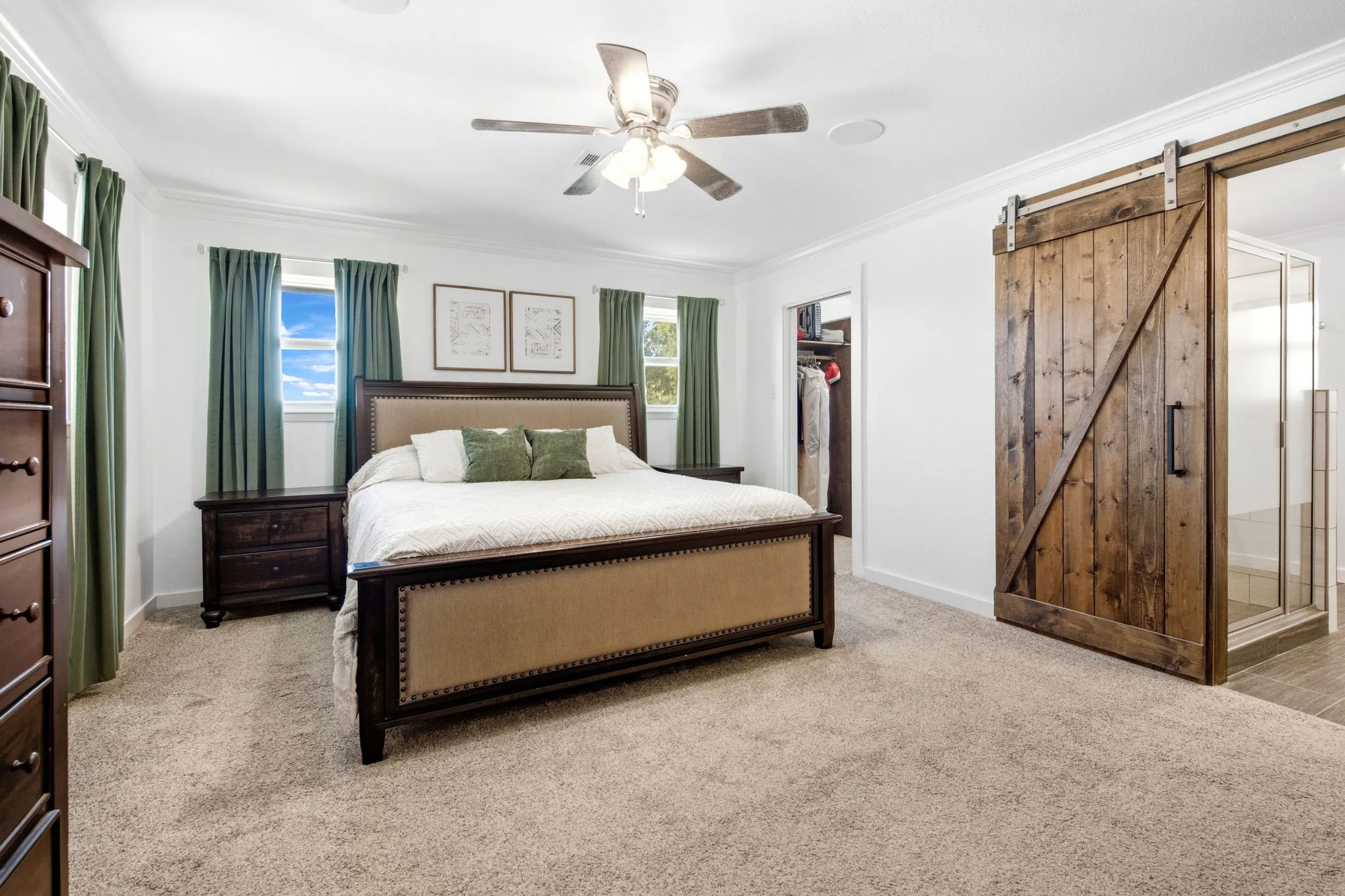 Primary bedroom with recessed lighting, ceiling fan, wood-finish barn door, carpeted flooring, and crown molding