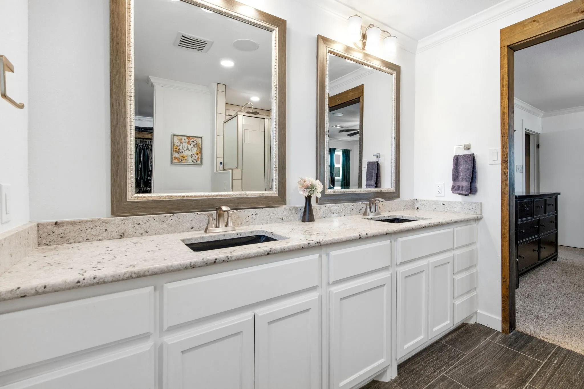 Dual vanity with white cabinetry and light-toned granite countertops